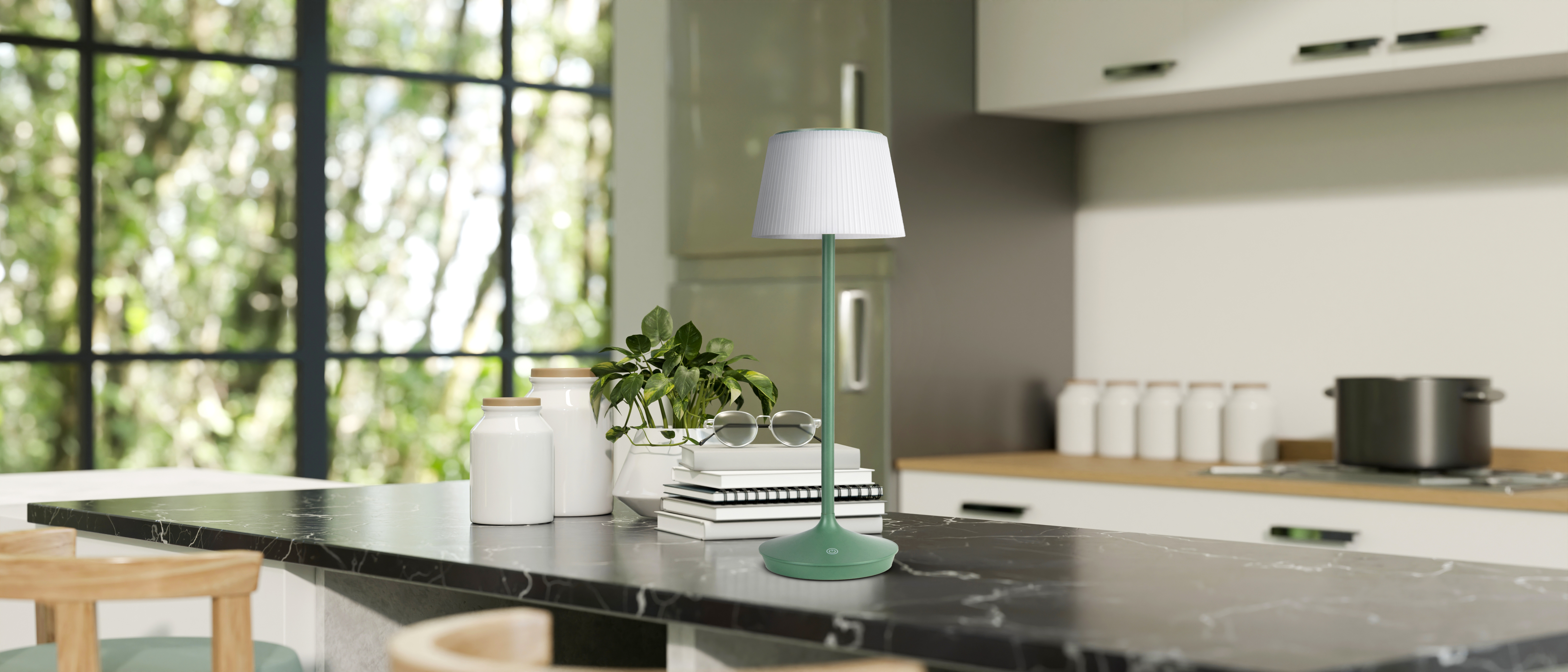 Grüne Lampe auf einer Arbeitsplatte. Küchenhintergrund mit Fenstern, Pflanzen und anderen Gegenständen.