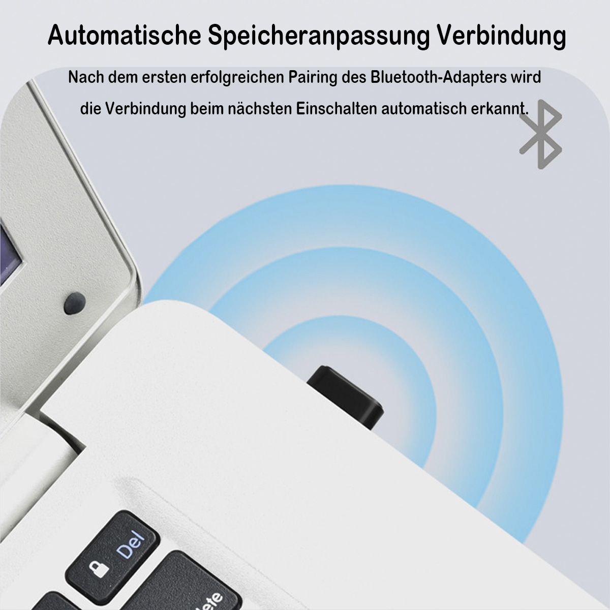 Nahaufnahme eines Laptops und eines kleinen schwarzen Bluetooth-Adapters.