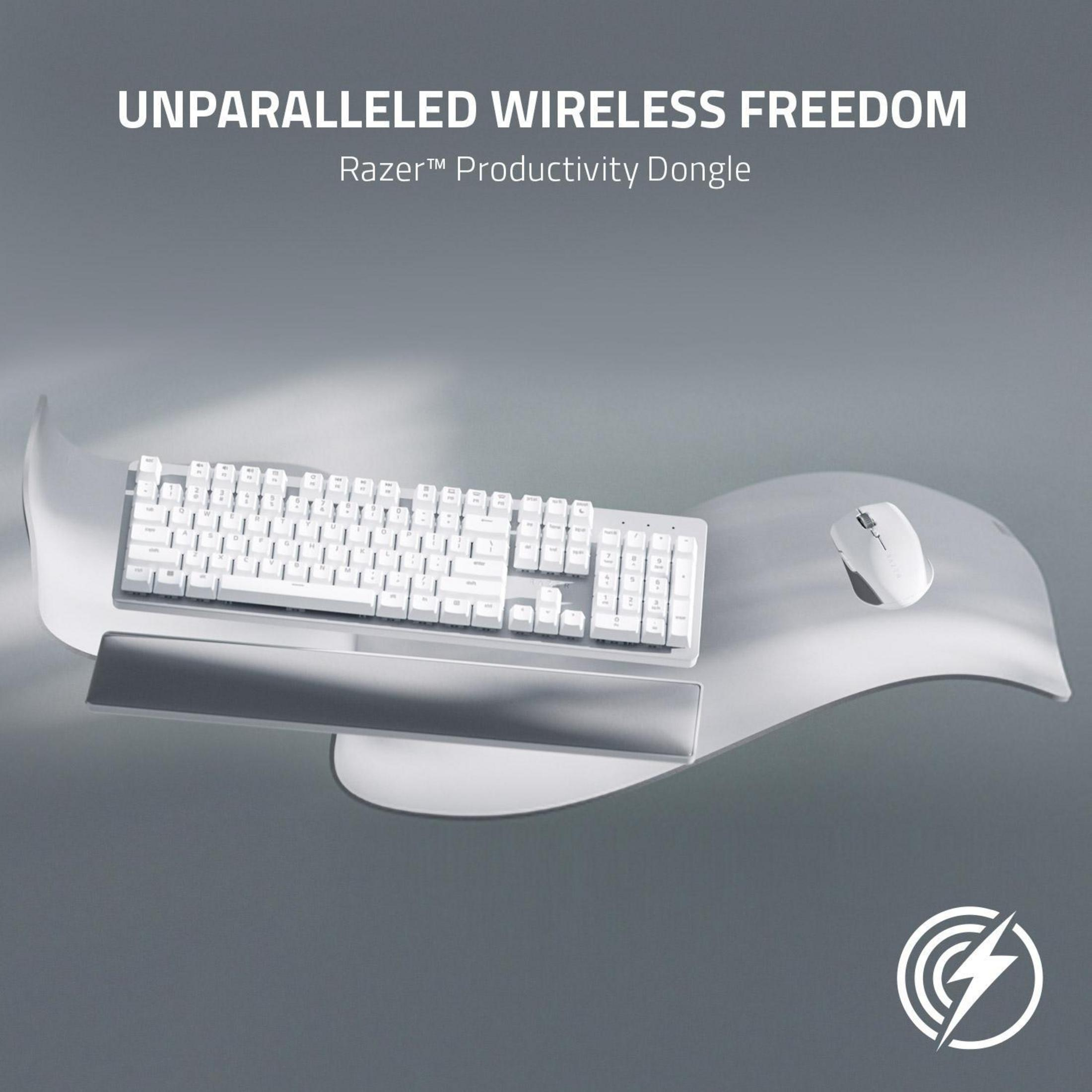 Weiße Tastatur, Maus und Handgelenkauflage auf einer weißen, wellenförmigen Schreibtischunterlage.