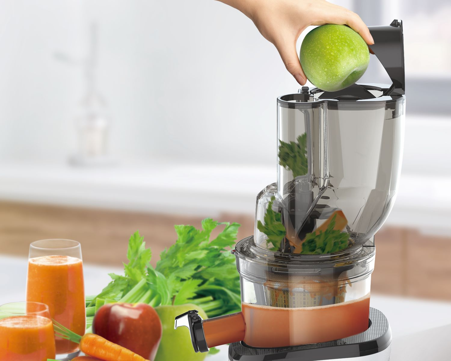 Mano colocando manzana verde en exprimidor, con zumos y frutas.