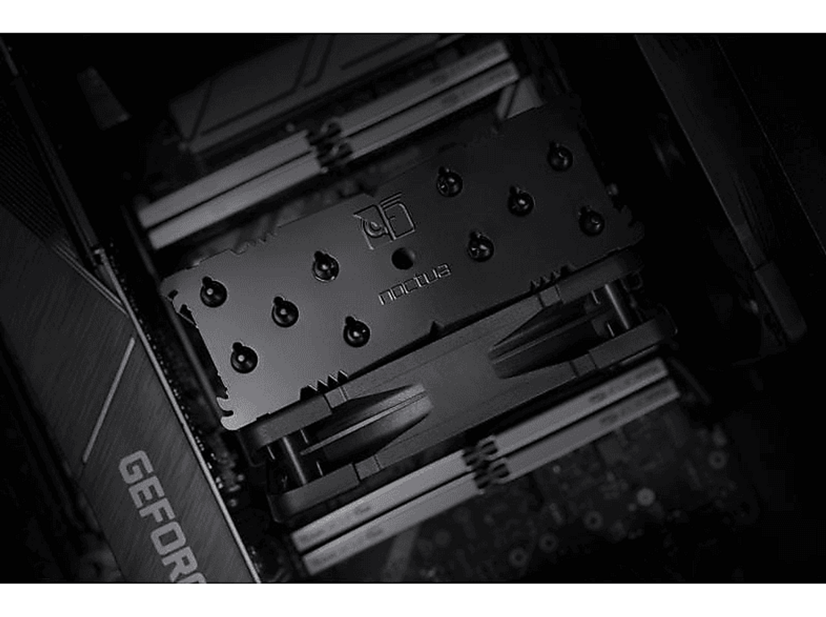 Zbliżenie czarnego chłodzenia procesora zainstalowanego na płycie głównej, widoczny RAM.