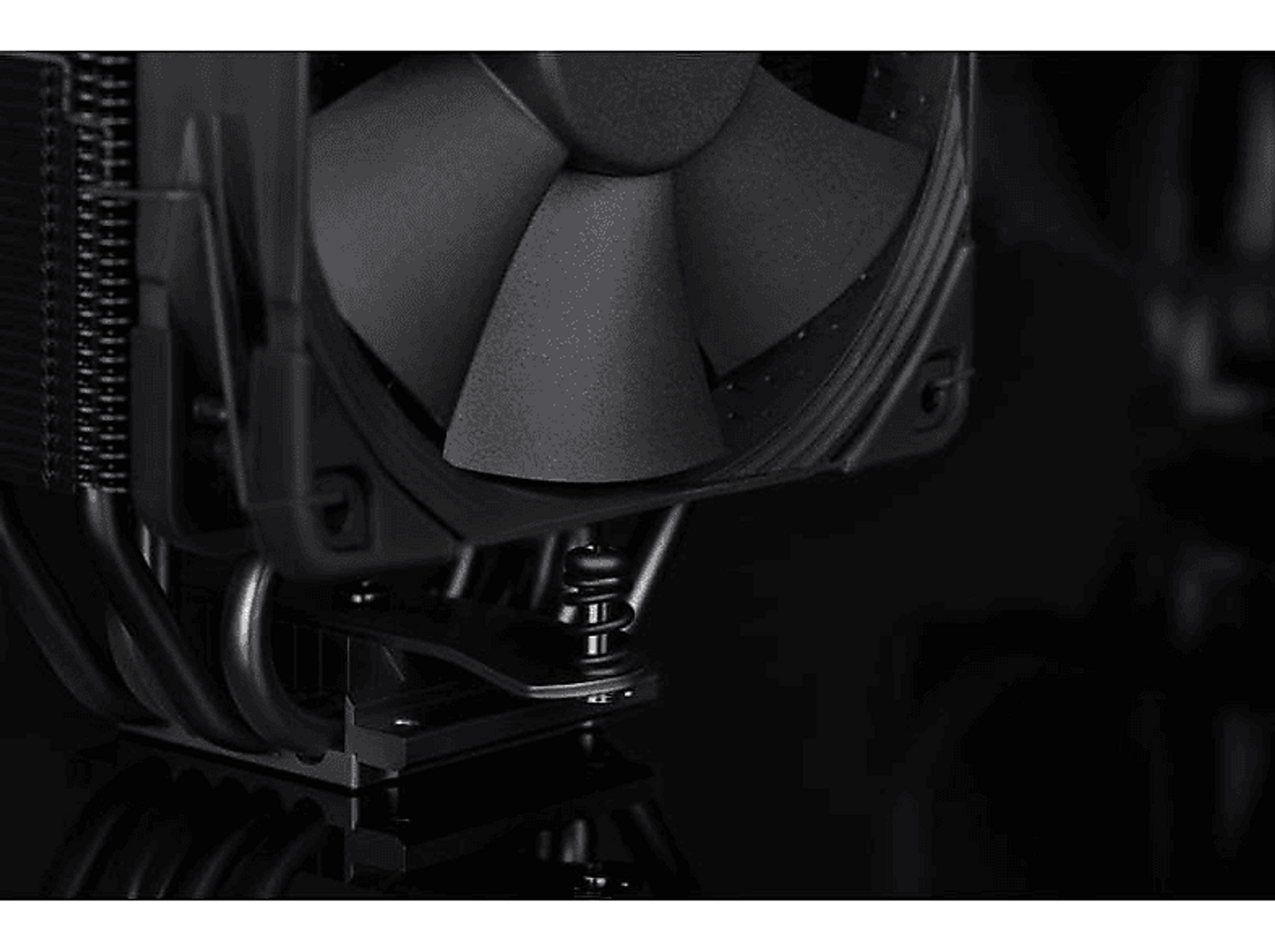 Zbliżenie czarnego chłodzenia procesora z łopatkami wentylatora i rurkami cieplnymi. Ciemne tło.