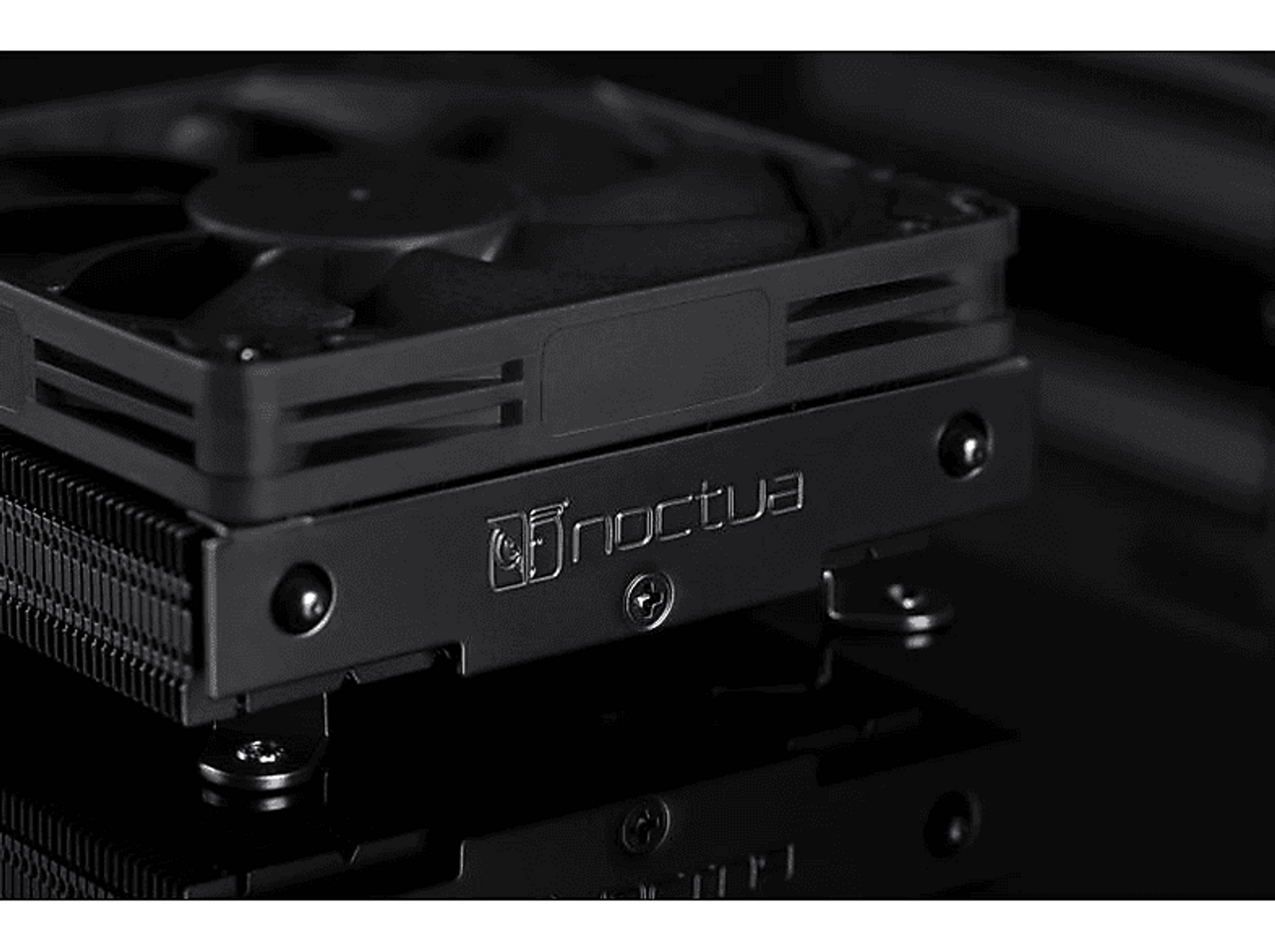 Czarny cooler CPU Noctua z nazwą marki, zbliżenie na ciemnym tle.