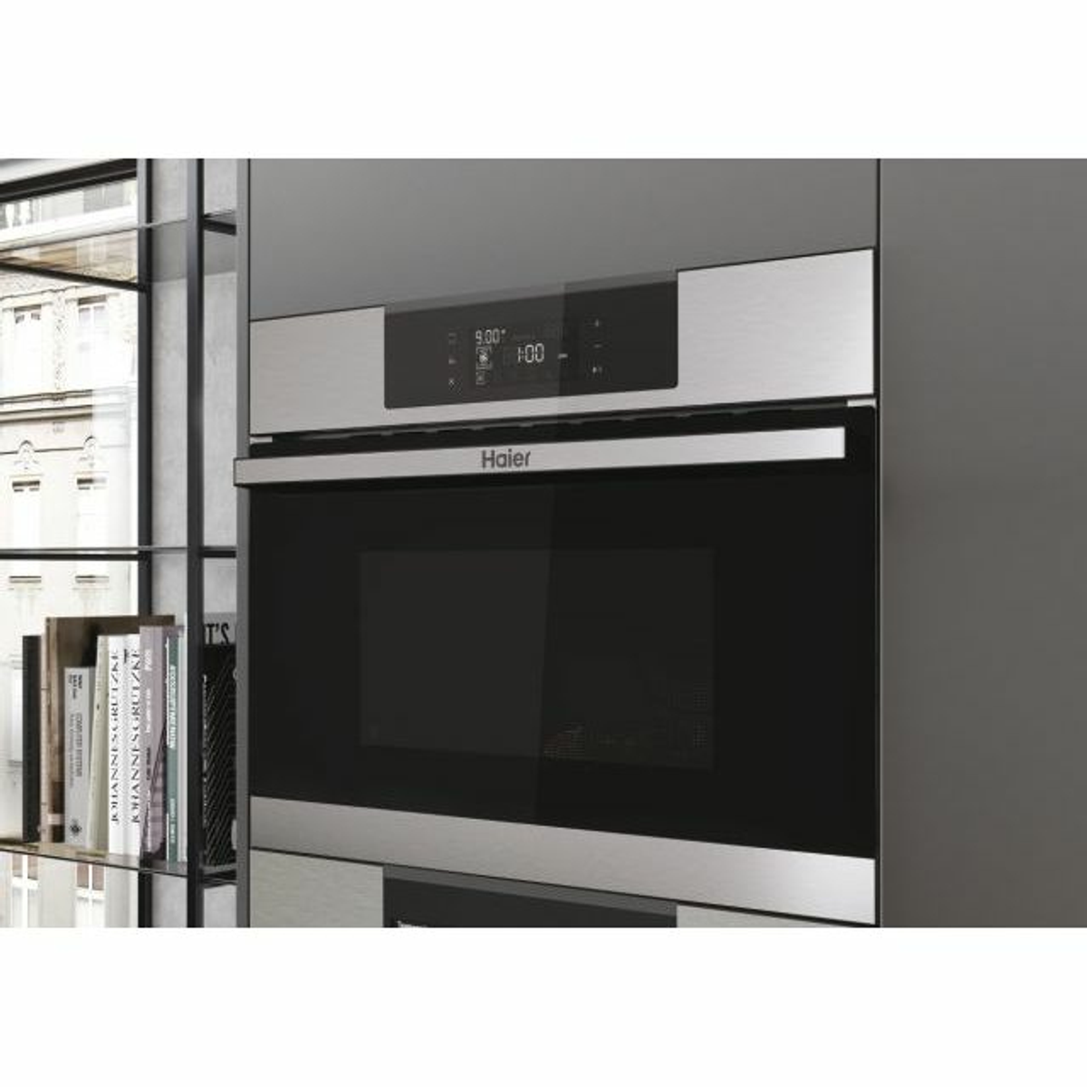 Kuchenka mikrofalowa ze stali nierdzewnej wbudowana w szafkę. Widoczna nazwa marki 'Haier'.