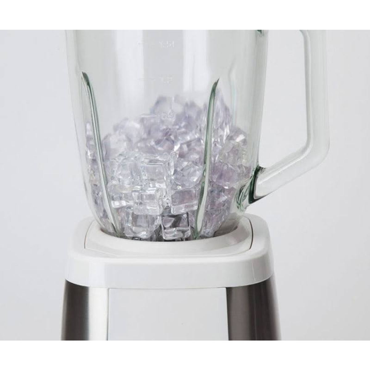 Licuadora con cubitos de hielo en un tarro de vidrio. Base blanca, tarro transparente.