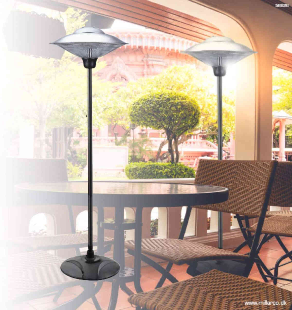 Zwei Heizstrahler stehen auf einer Terrasse mit Tischen und Stühlen. Bäume und Himmel im Hintergrund.