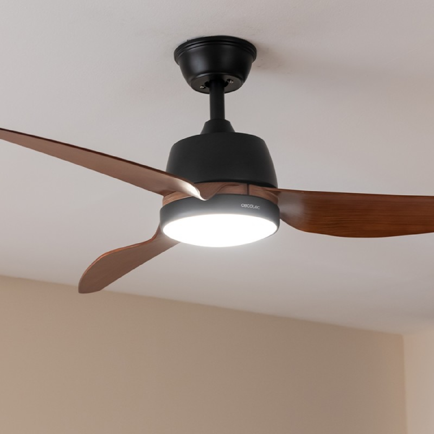 Ventilador de techo con tres aspas, una lámpara y una carcasa del motor negra.