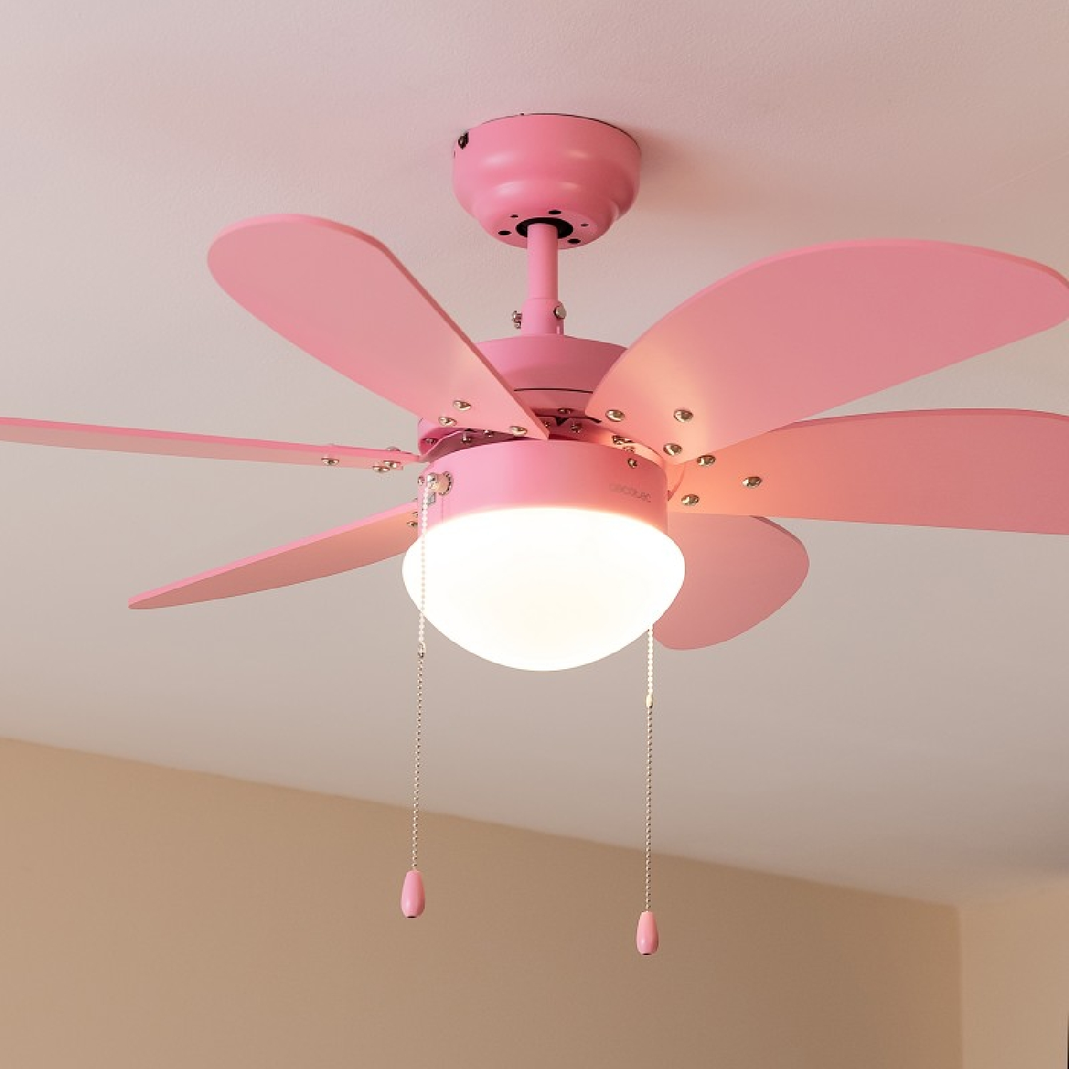 Un ventilatore da soffitto rosa con cinque pale e un'apparecchio di illuminazione.