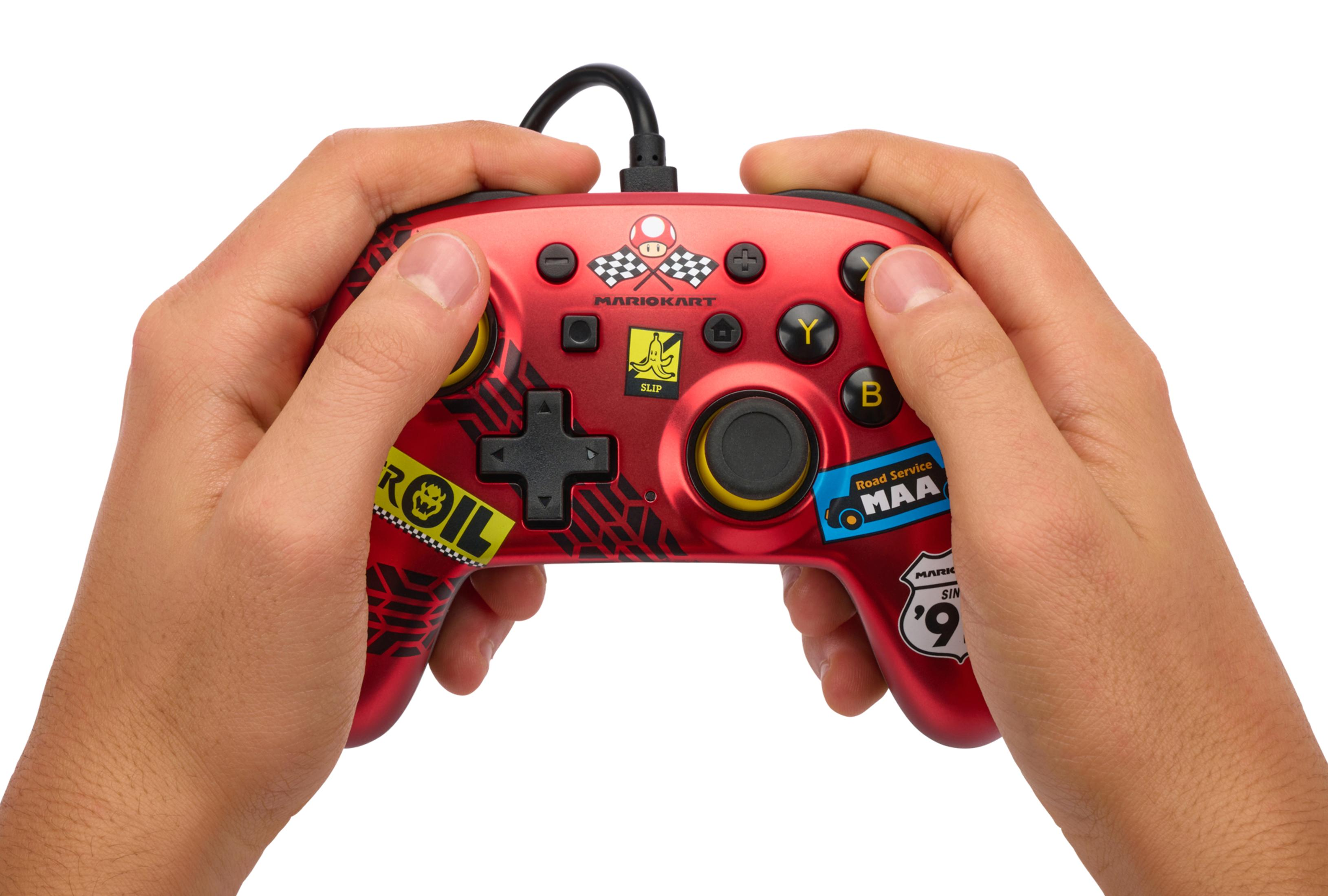Handen die een rode Mario Kart-controller vasthouden met zwarte kabel, Y, B, X en A-knoppen.