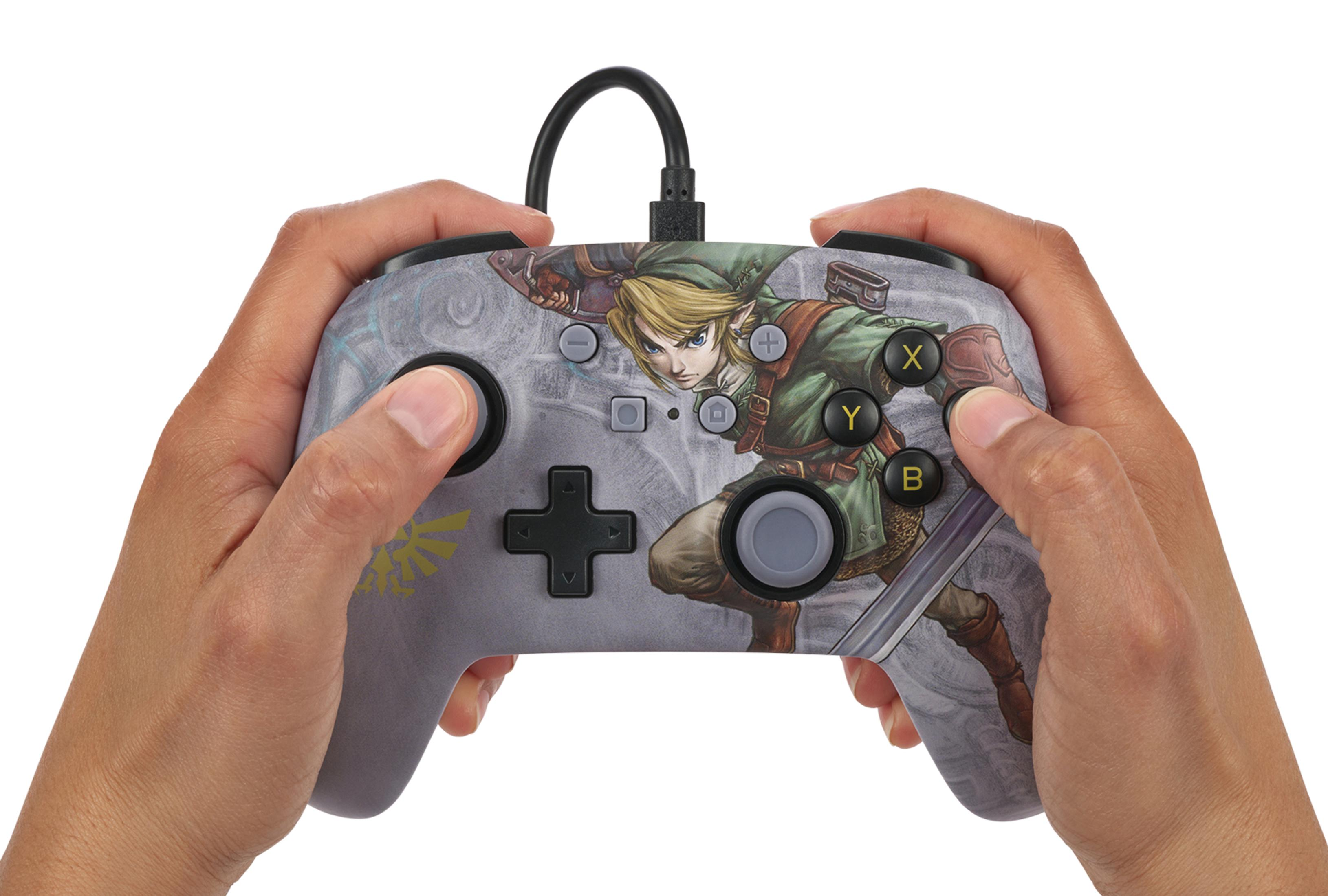 Hände halten einen grauen Controller mit Link-Design.