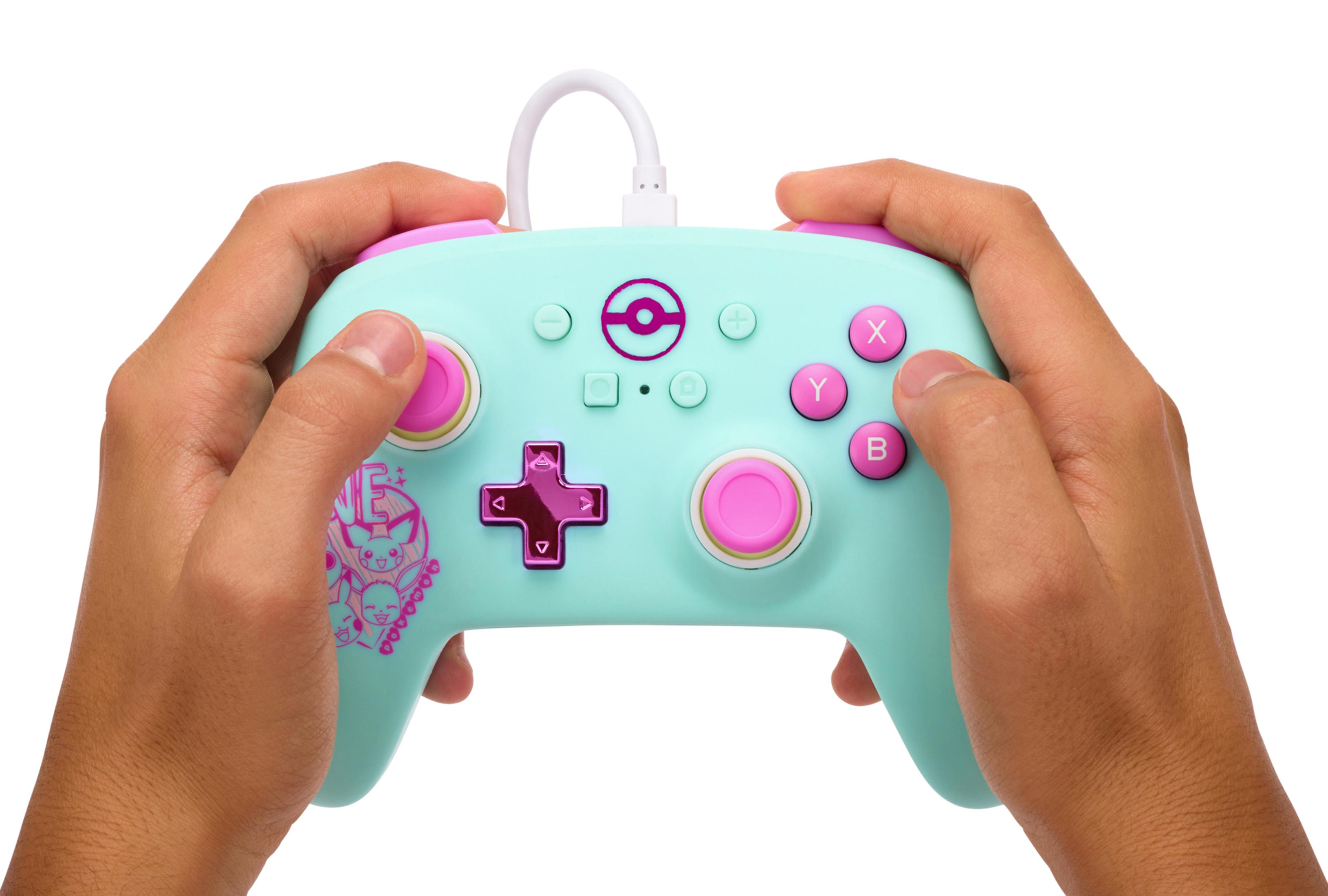 Hände halten einen hellblauen Gamecontroller im Pokemon-Design auf weißem Hintergrund.