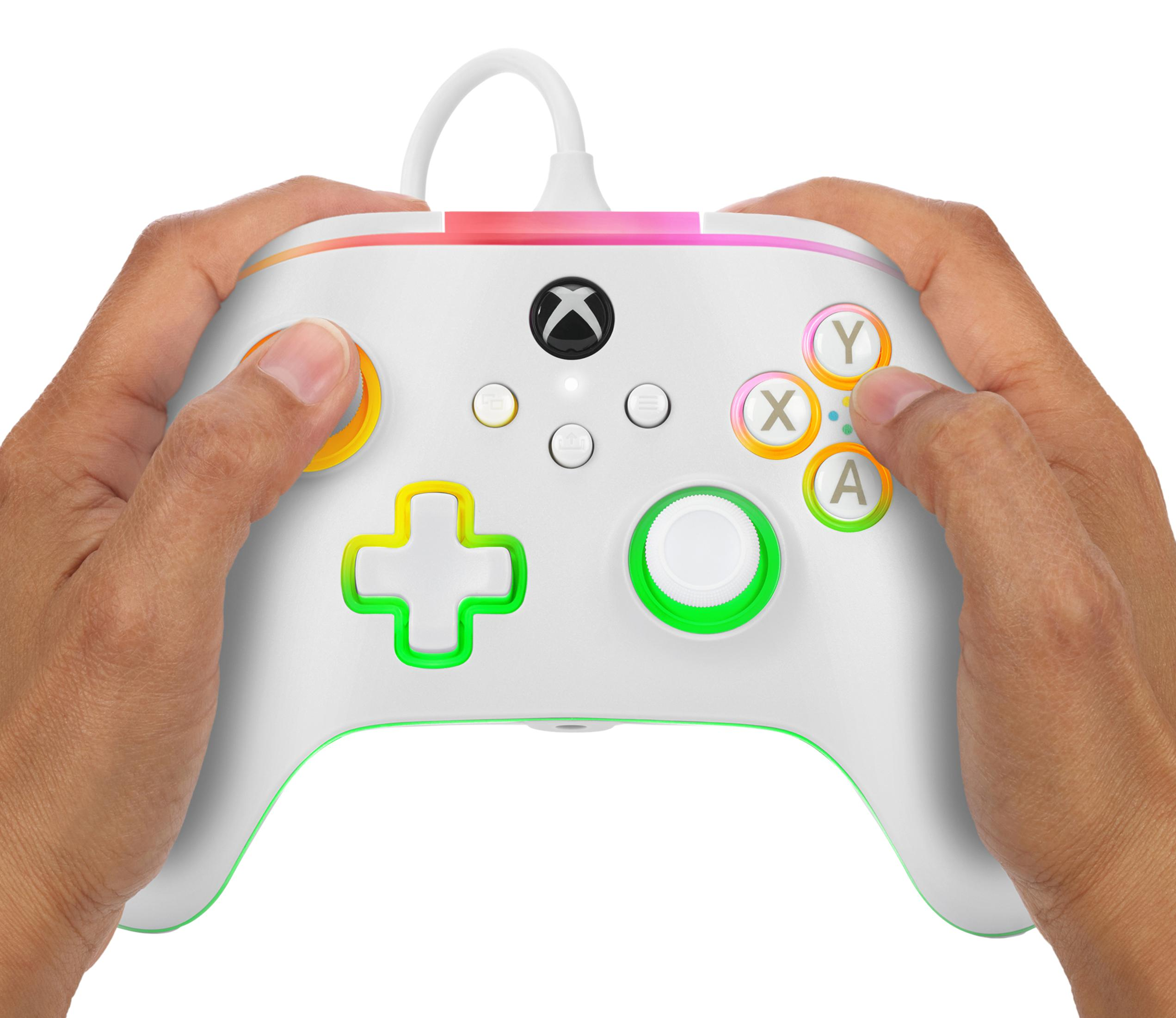 Biały kontroler Xbox z kolorowymi przyciskami. Trzymany przez dwie ręce, tęczowe akcenty.