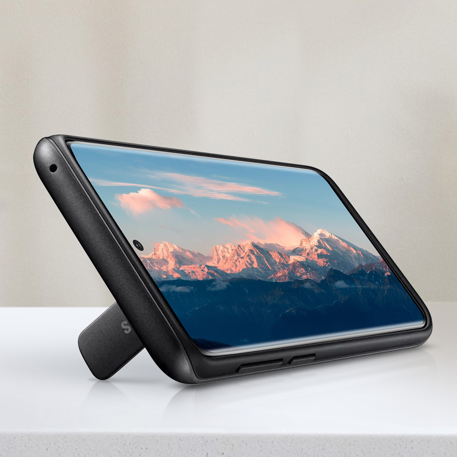 Eine schwarze Handyhülle, die ein Handy mit Berg- und Himmelhintergrund zeigt.