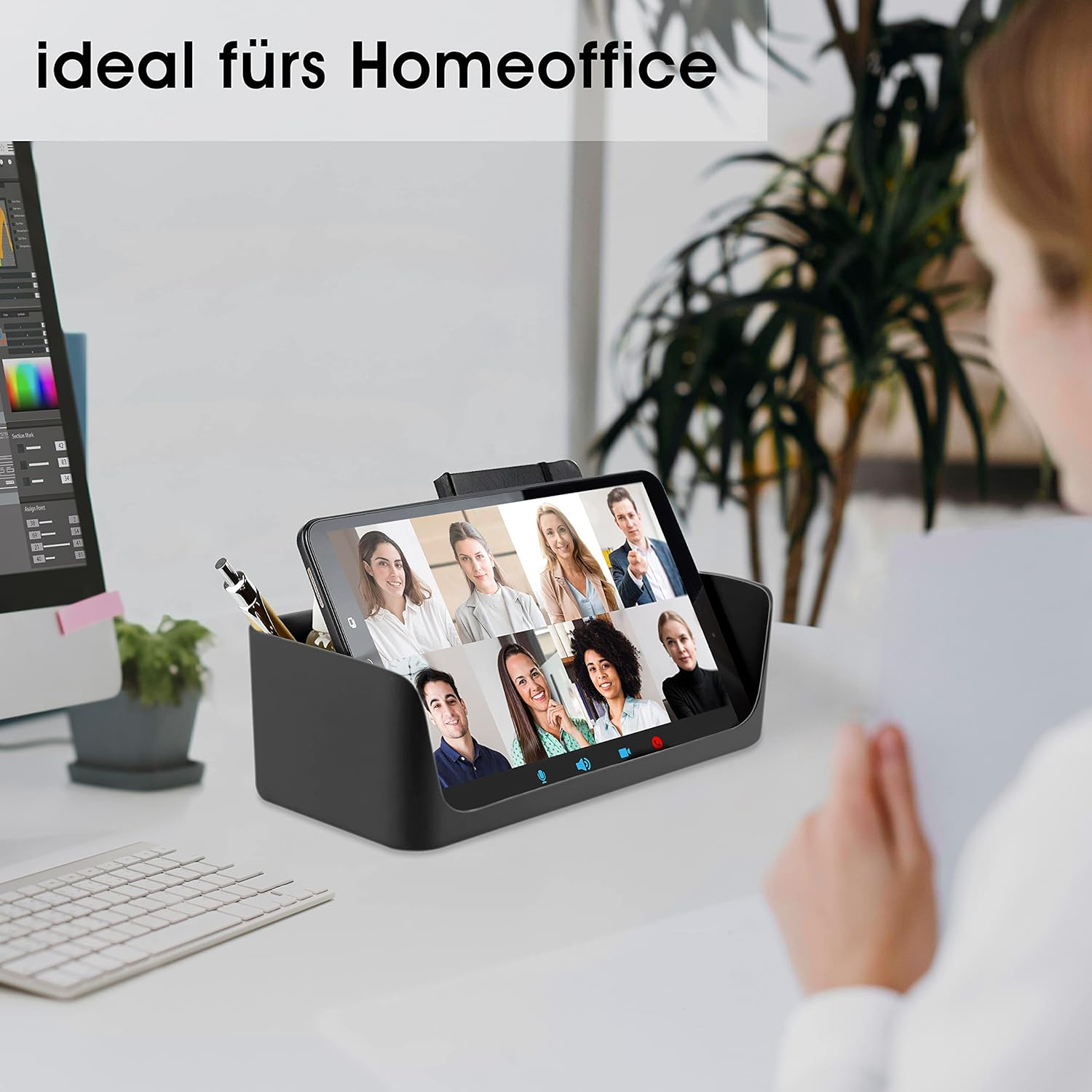 Ein Schreibtisch mit einem Tablet, das eine Videokonferenz zeigt, einem Stift und einer Tastatur; ideal für Homeoffice.