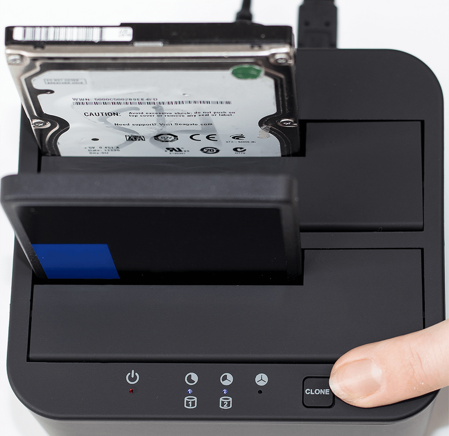 Czarny duplikator dysków twardych z dyskami twardymi i palcem naciskającym 'CLONE'.