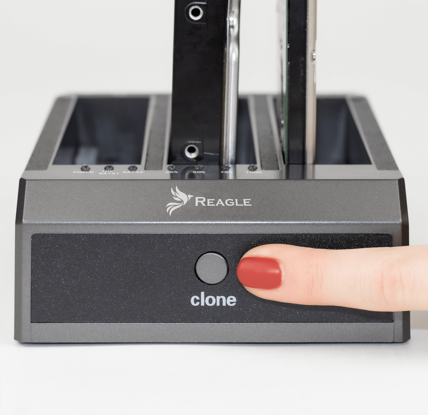 Duplikator dysków twardych. Palec naciska przycisk klonowania. Dwa dyski twarde są włożone.