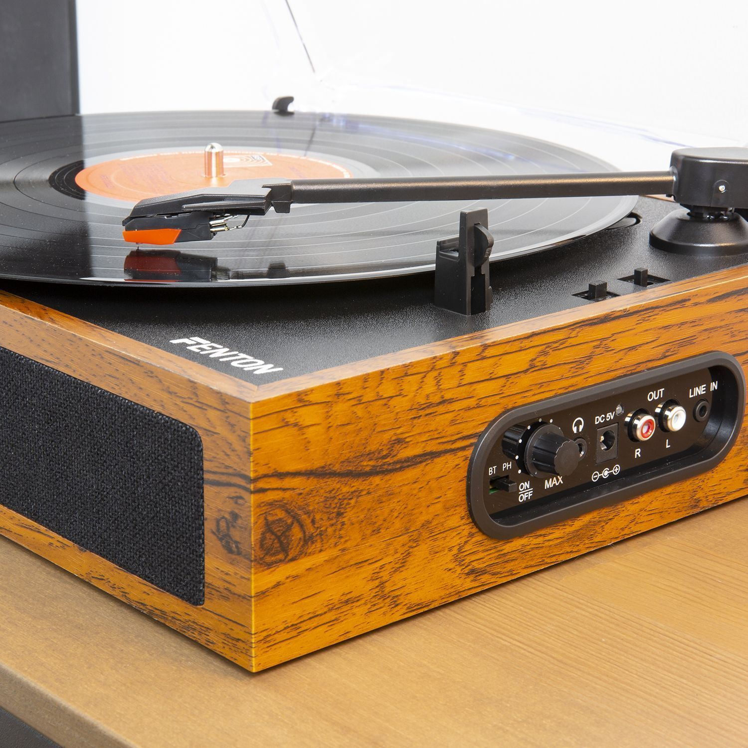 Wooden turntable with a black record playing music. Controls on front.