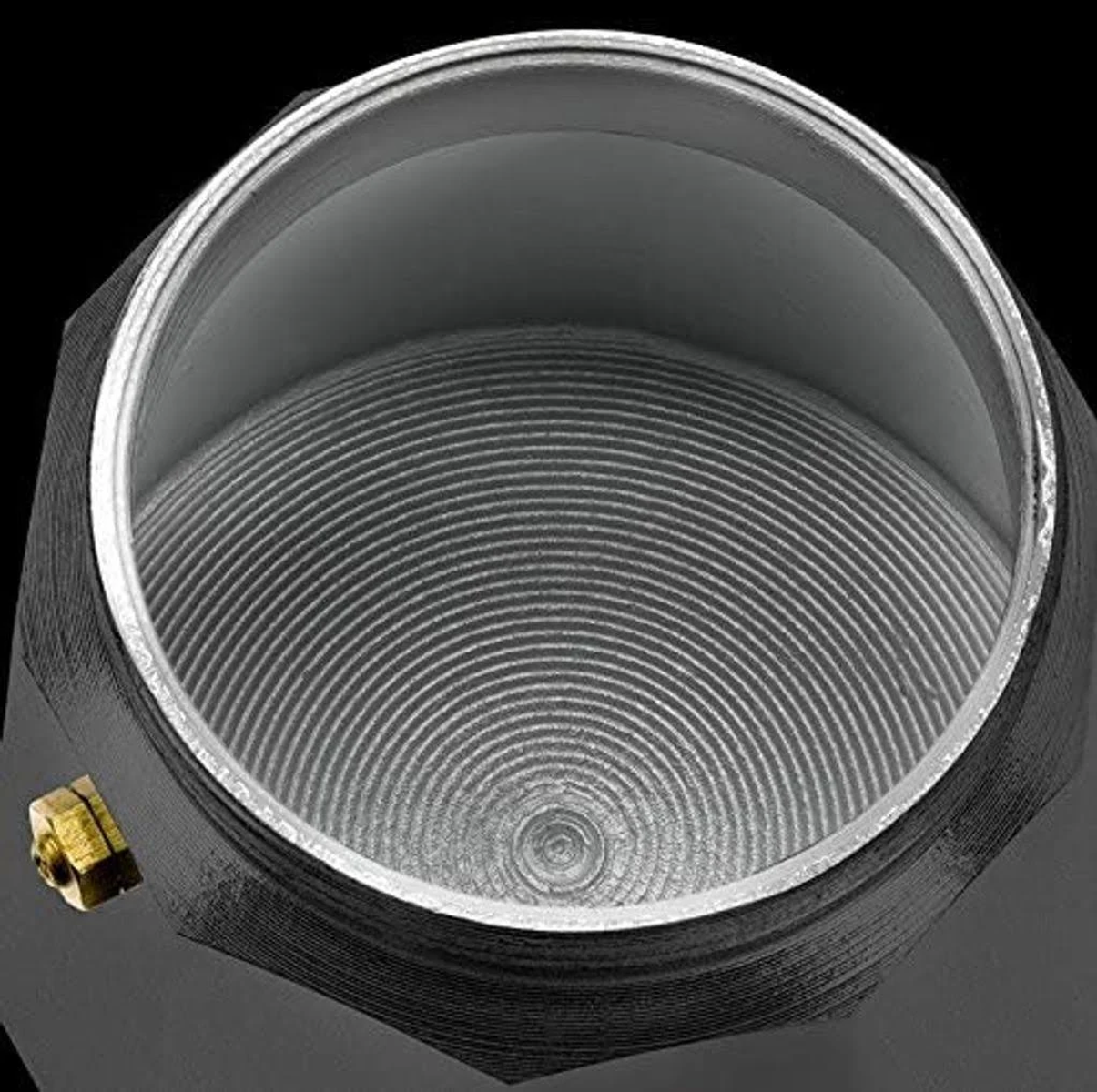 Vista superior de la cámara superior de una cafetera. Está hecha de metal con un patrón en espiral en el interior.