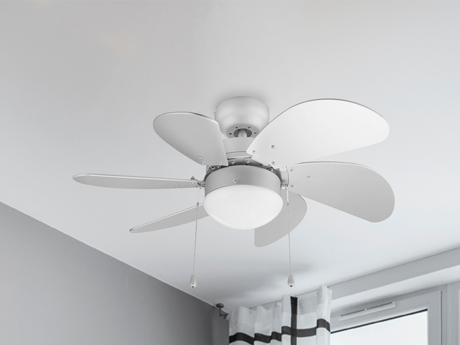Ein weißer Deckenventilator mit fünf Flügeln und einer zentralen Leuchte, an einer weißen Decke.