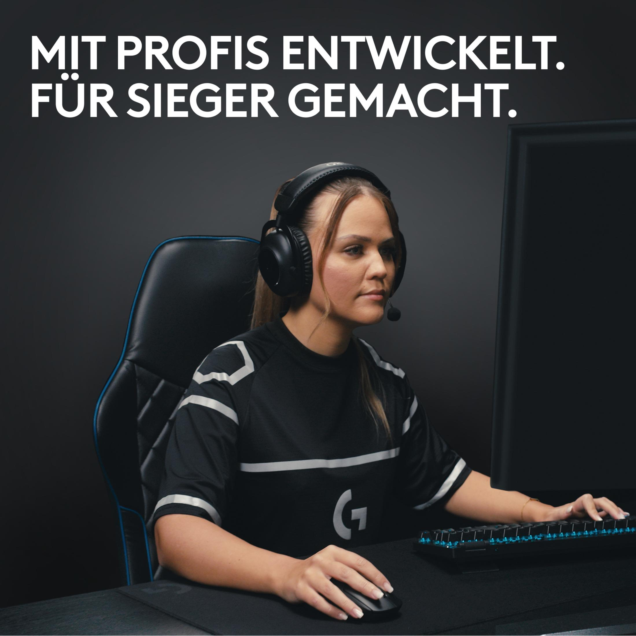Une femme portant un casque et un casque joue à des jeux sur un bureau.
