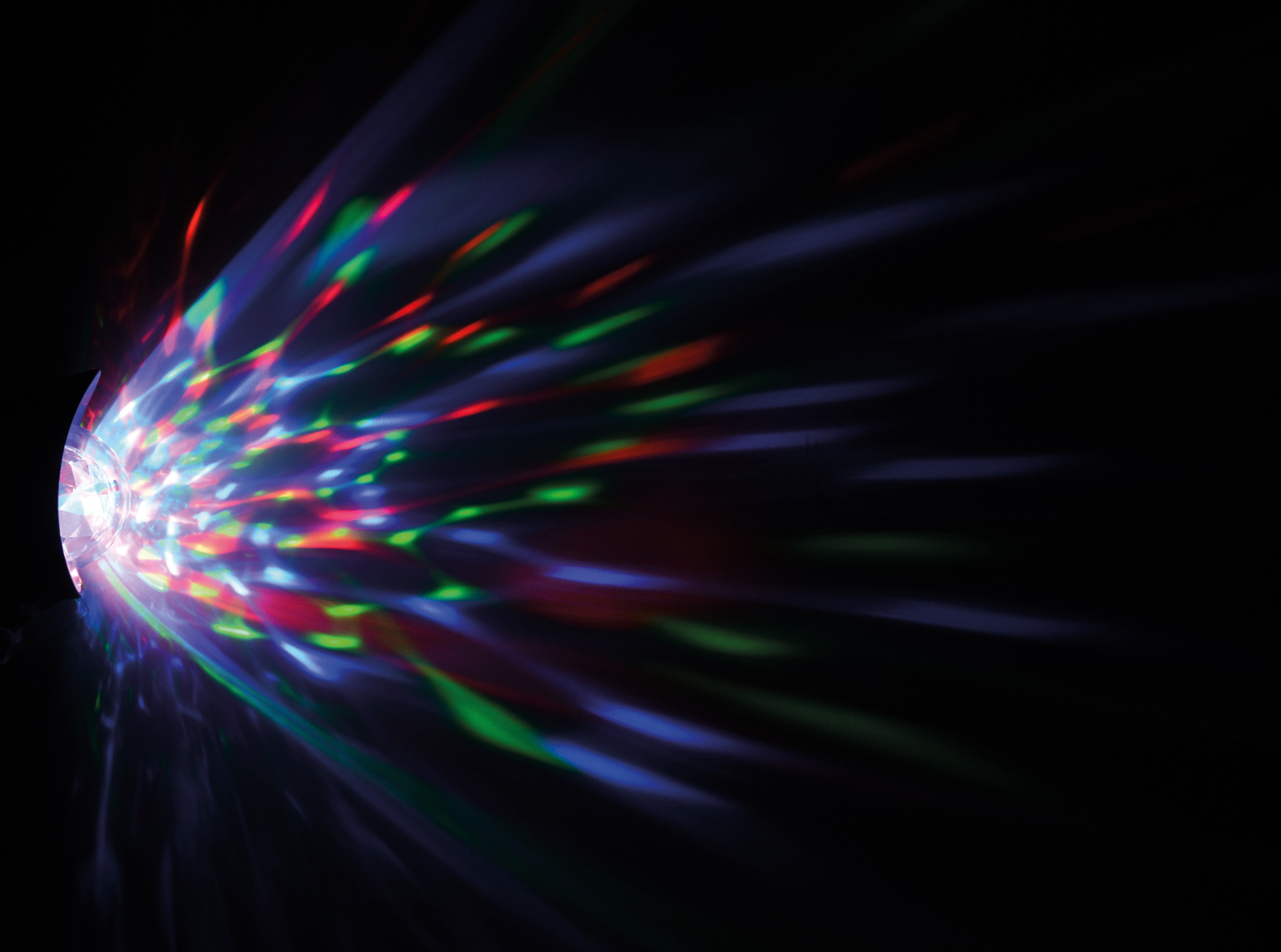 Ein Lichtprojektor, der farbige Lichtstrahlen vor einem schwarzen Hintergrund aussendet.