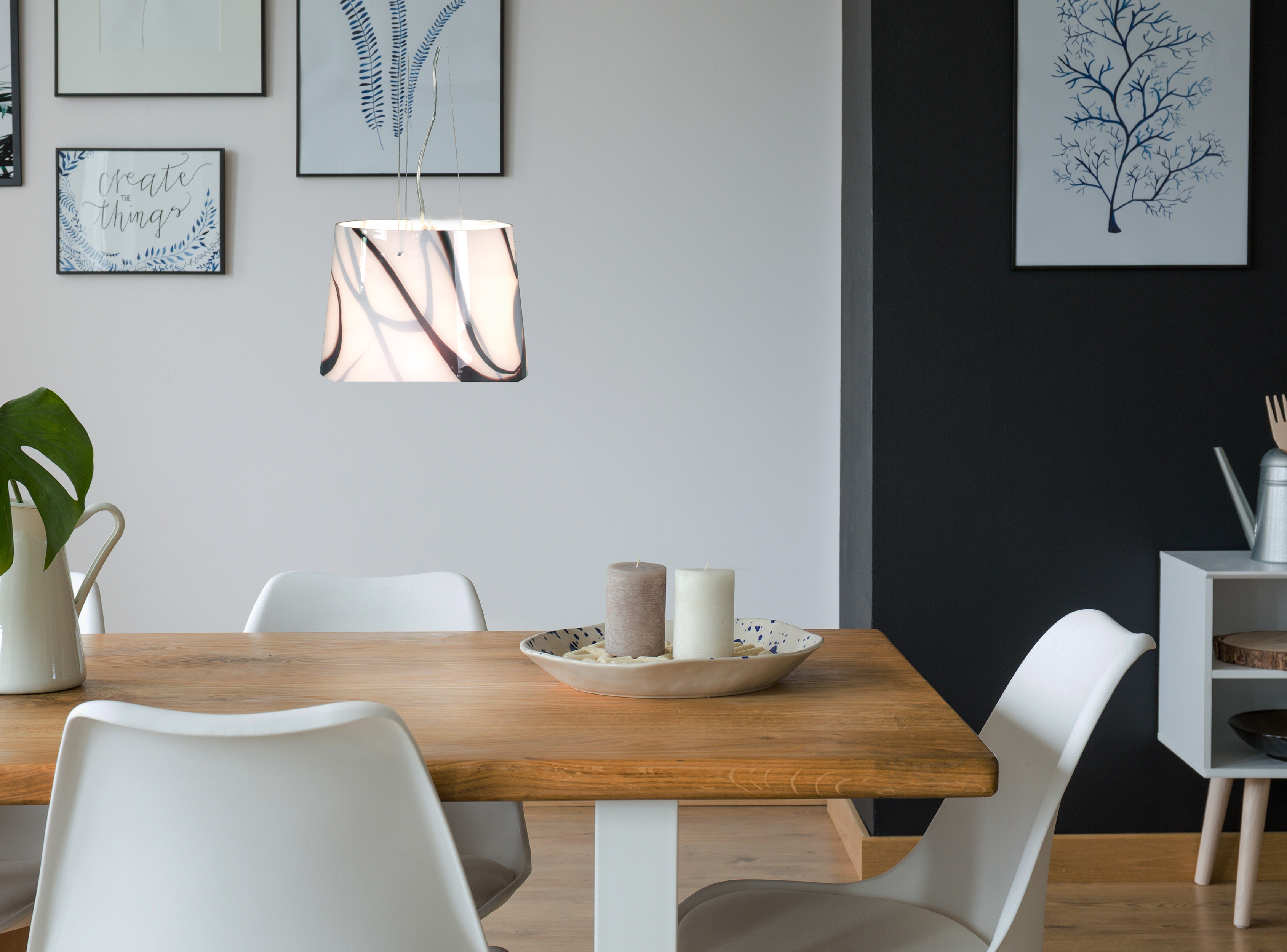 Esszimmer mit Holztisch, weißen Stühlen und dekorativen Gegenständen.