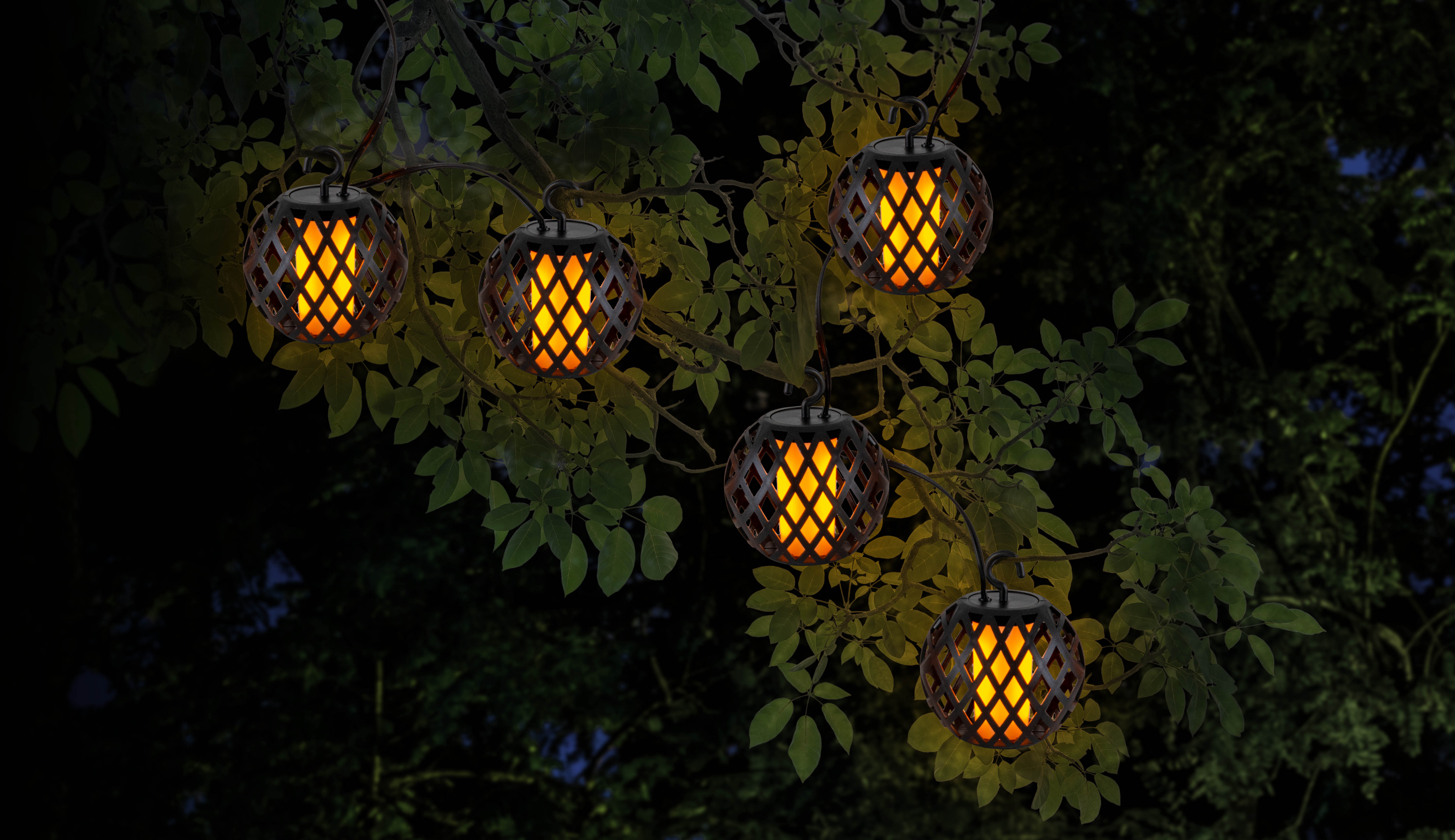 Hängende Laternen im Freien mit flammenartigen Lichtern, angeordnet in einem Baum, vor dunklem Nachthimmel.