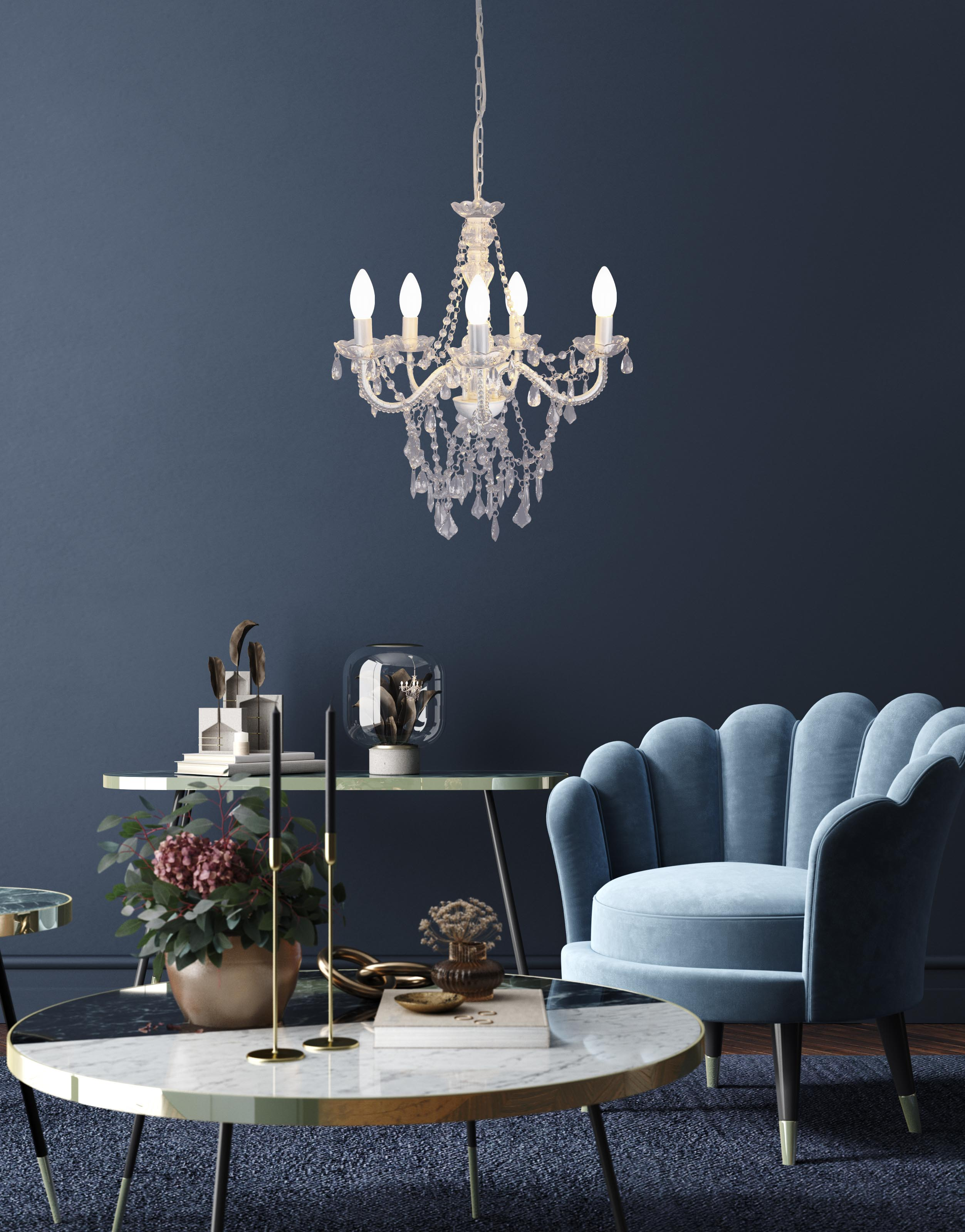 Wohnzimmer mit Kronleuchter, blauem Sessel, Couchtisch und dekorativen Elementen.