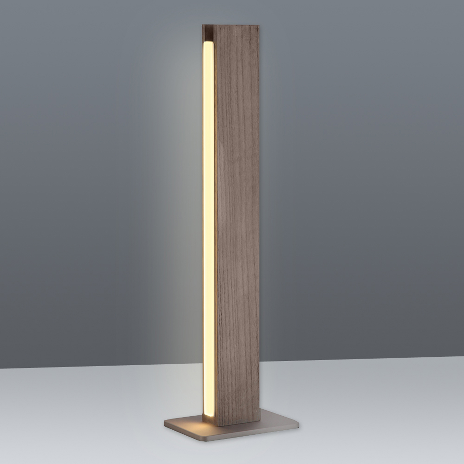 Eine hohe Holzlampe mit einem beleuchteten vertikalen Streifen.