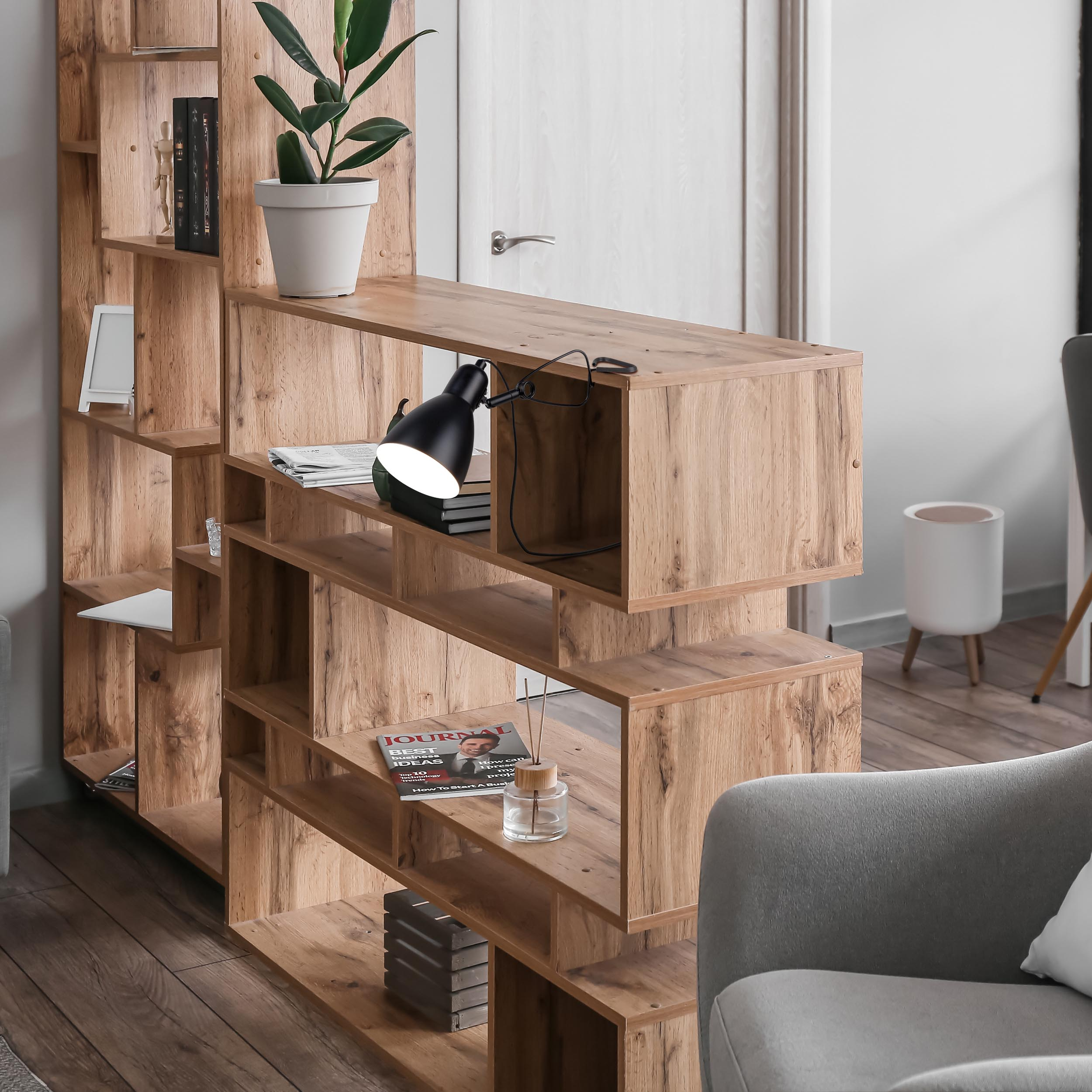 Holzregal mit Pflanze und Büchern. Schwarze Lampe und grauer Stuhl sichtbar.