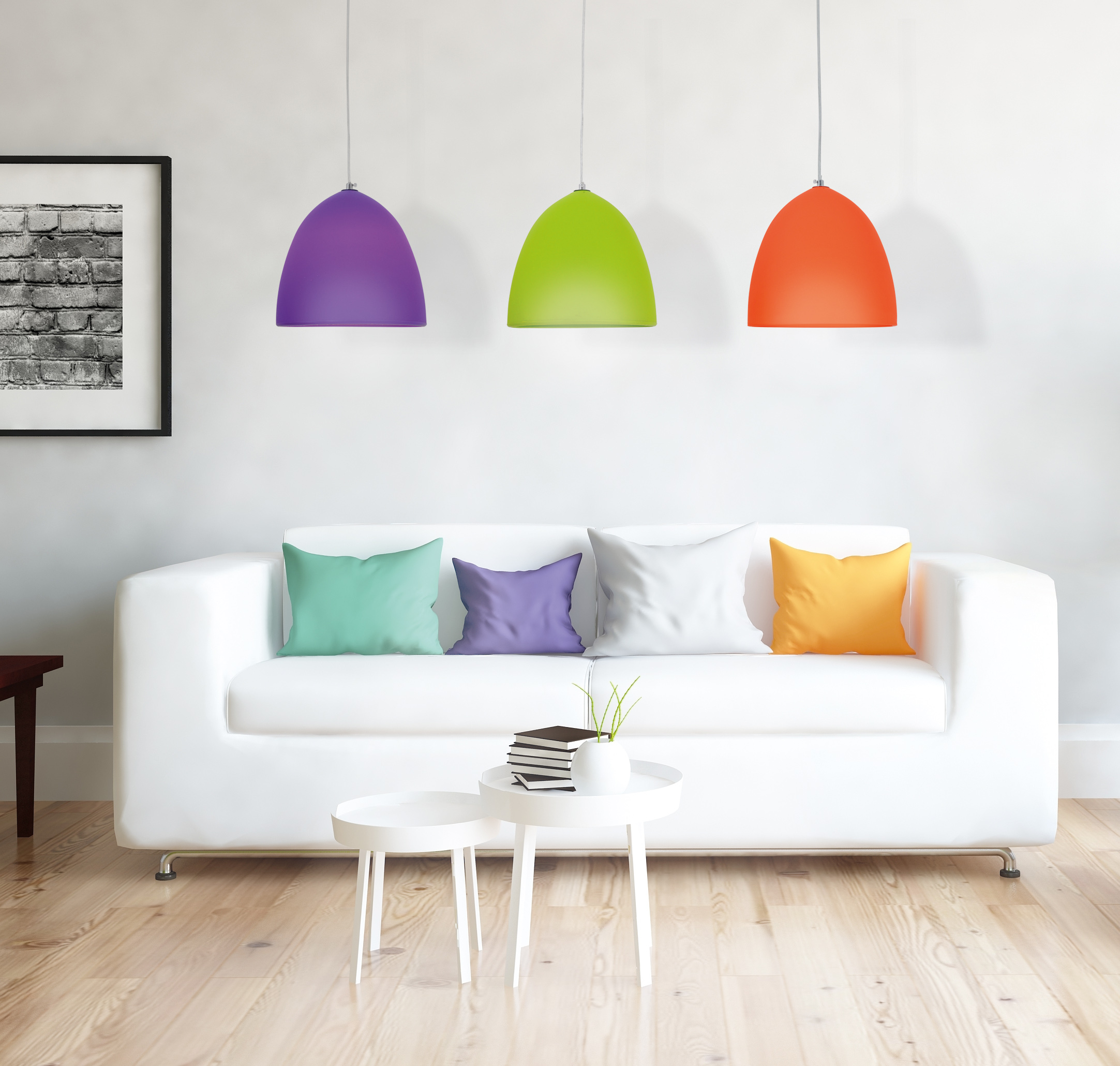 Wohnzimmer mit weißem Sofa, farbigen Pendelleuchten und Kissen. Holzboden.