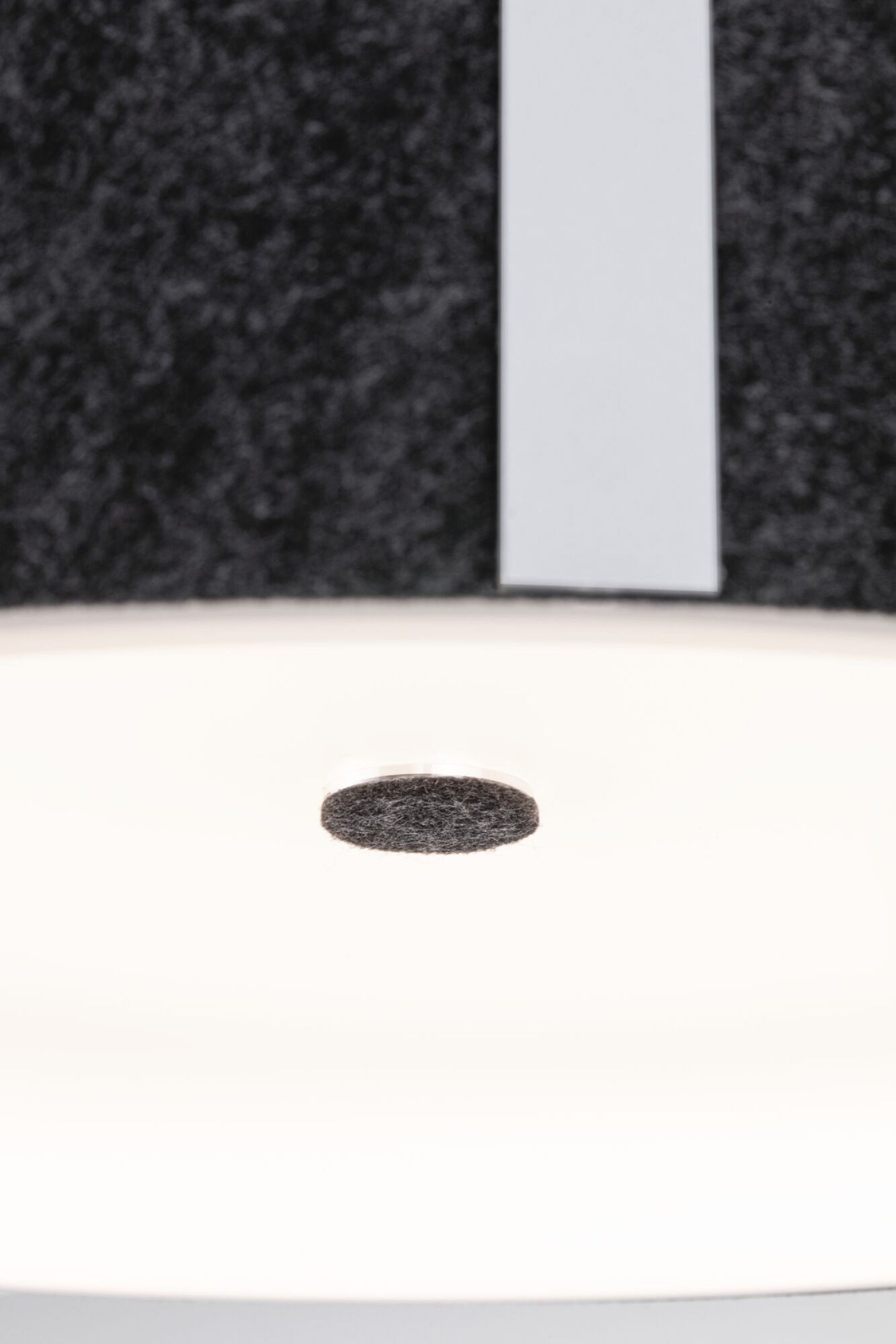 Zbliżenie białej okrągłej lampy wpuszczanej z ciemnym środkiem.