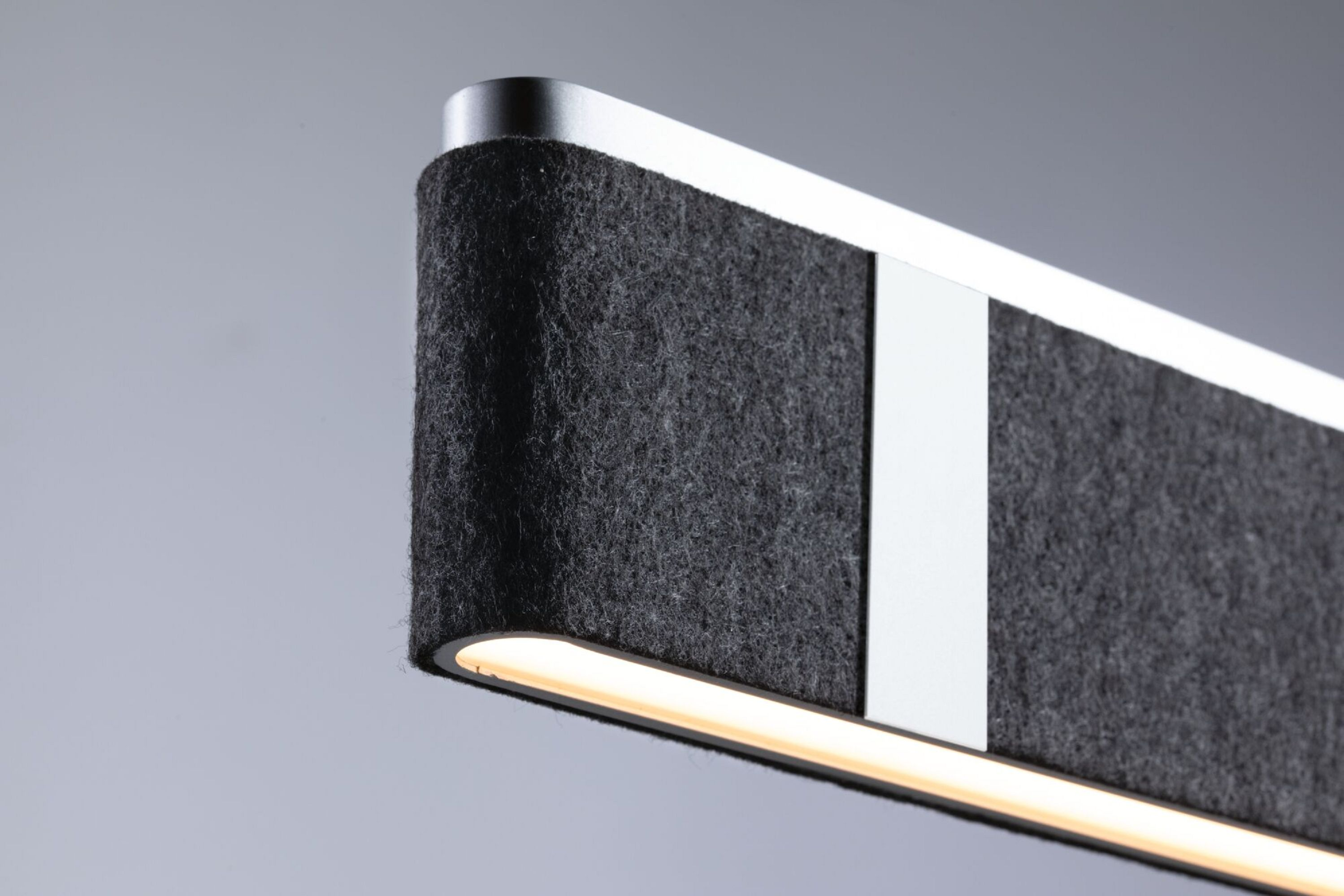 Zbliżenie szarej lampy z filcu z białym światłem.