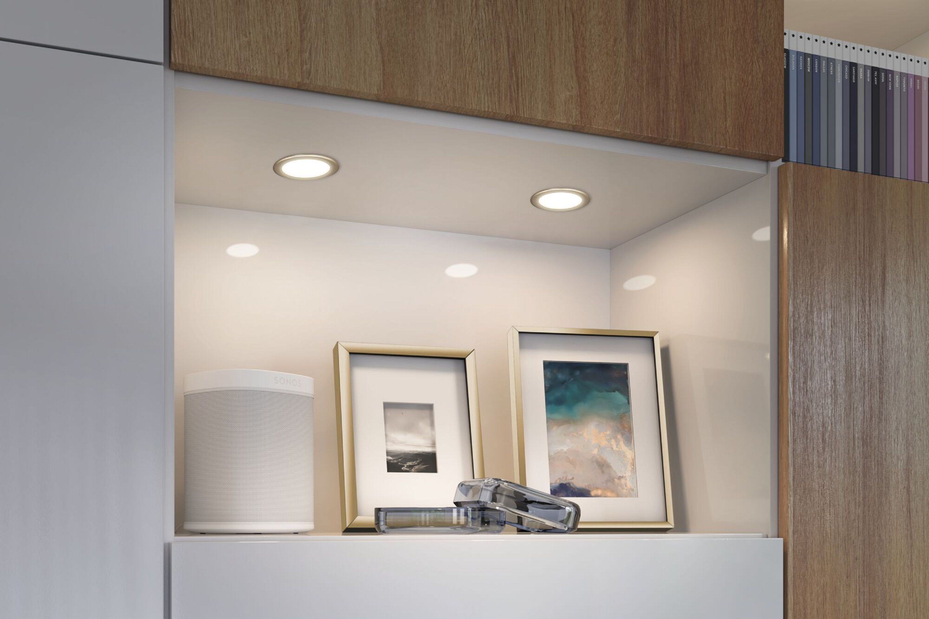 Półka z dwoma światłami wpuszczanymi, obrazami i głośnikiem.