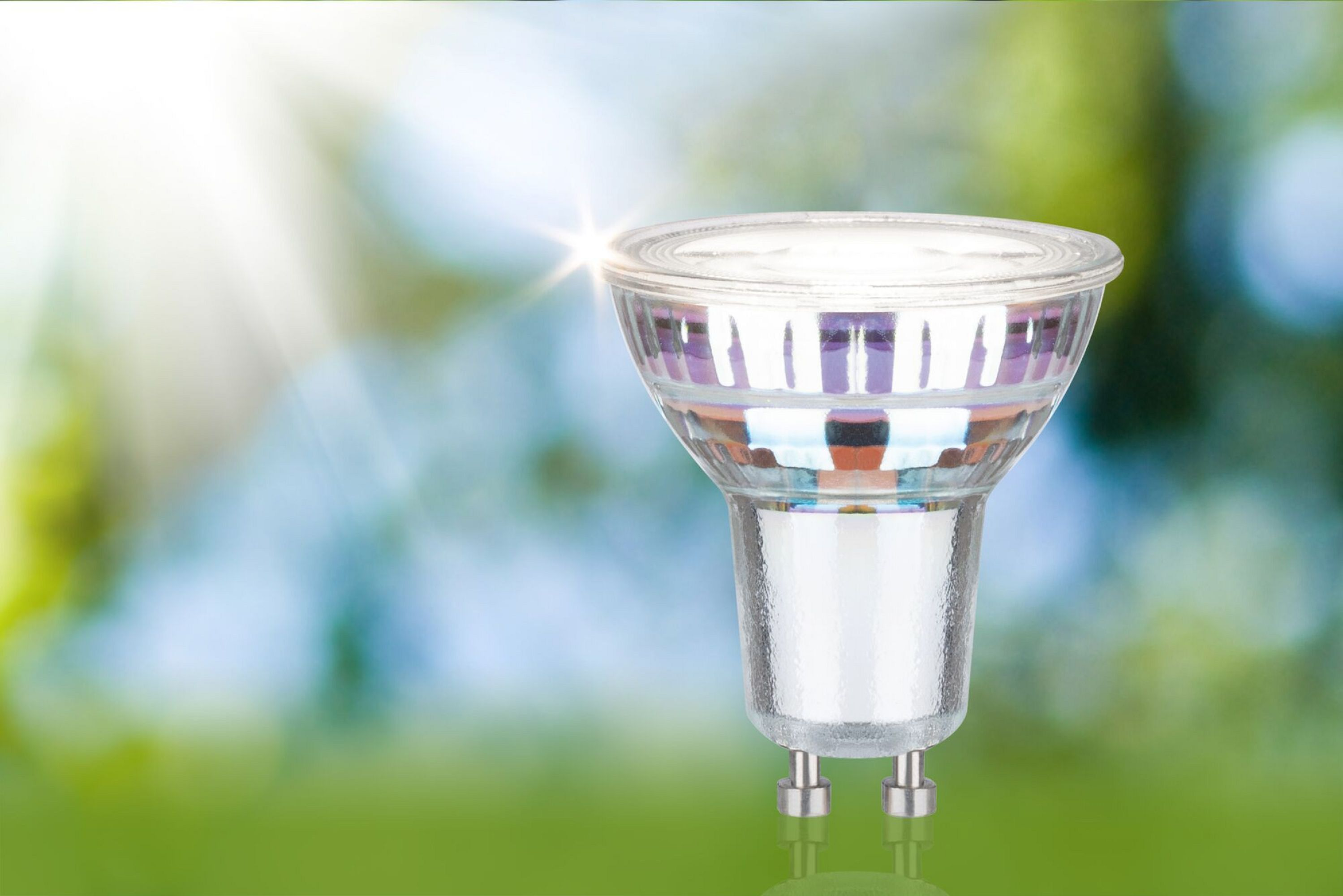 Eine klare Scheinwerferlampe. Die Glühbirne hat einen silbernen Sockel und befindet sich vor einem verschwommenen Hintergrund.