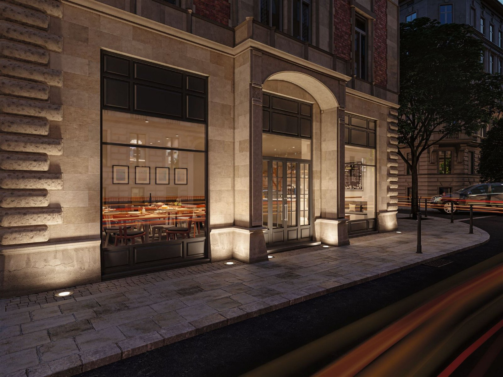 Zewnętrzne ujęcie restauracji z włączonymi światłami w nocy. Przejeżdża samochód.