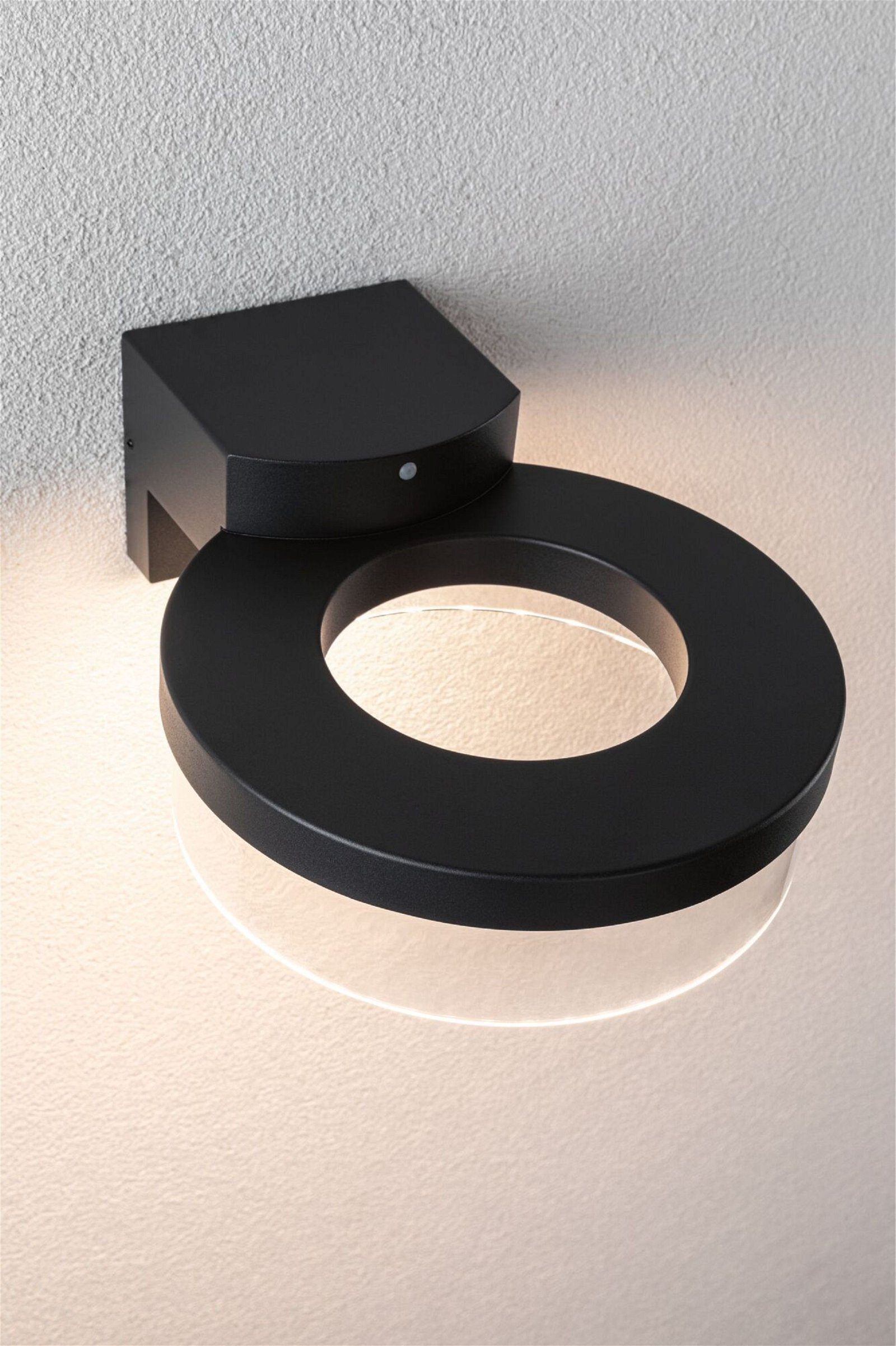 Czarna lampa ścienna o okrągłym kształcie i świetle.