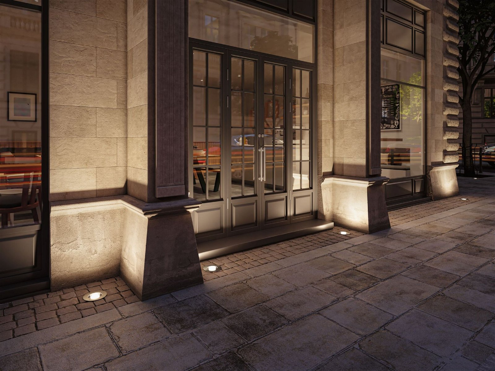 Zewnętrze budynku w nocy, ze światłami oświetlającymi wejście i chodnik. Ciemne niebo.