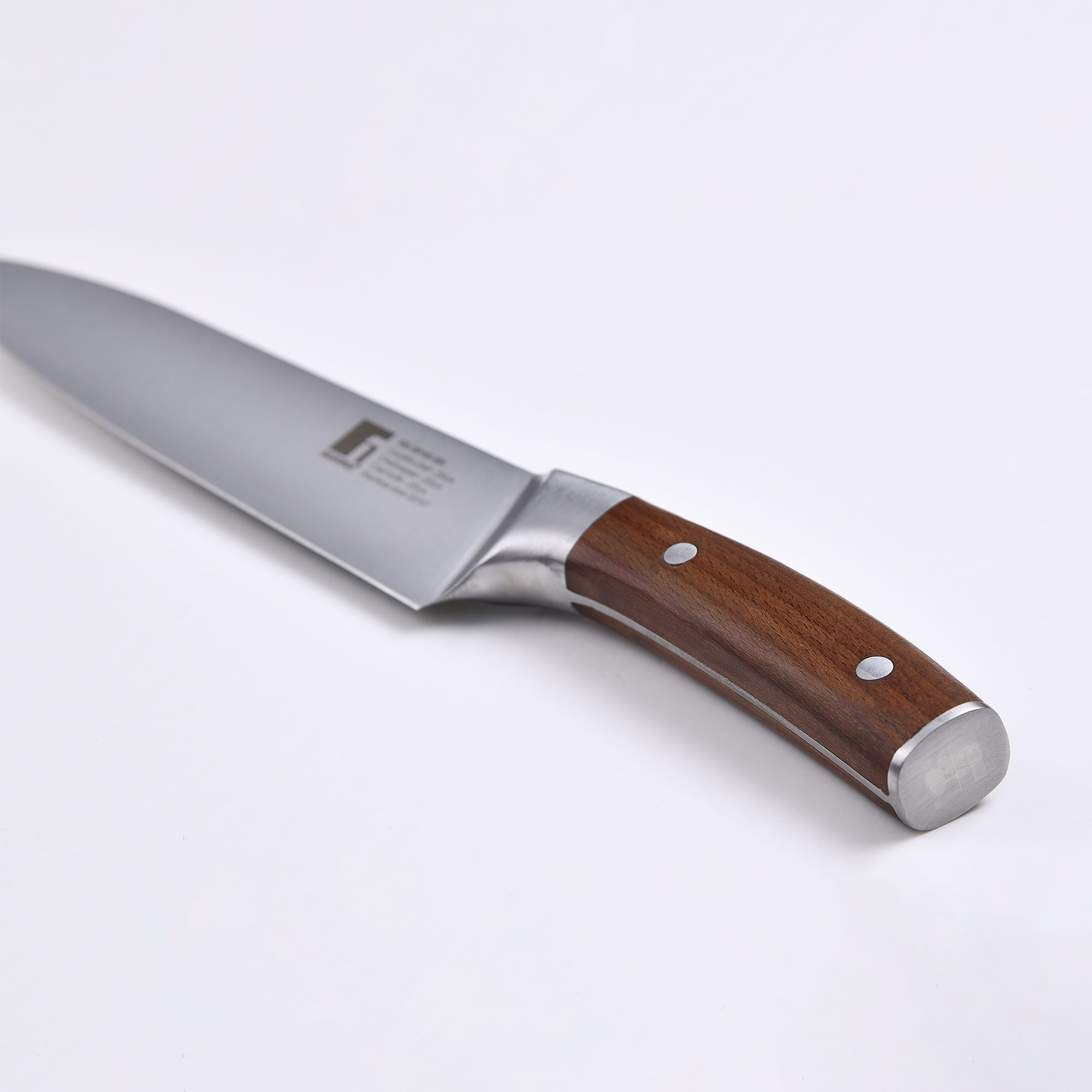 Cuchillo de cocina con mango de madera sobre una superficie blanca.