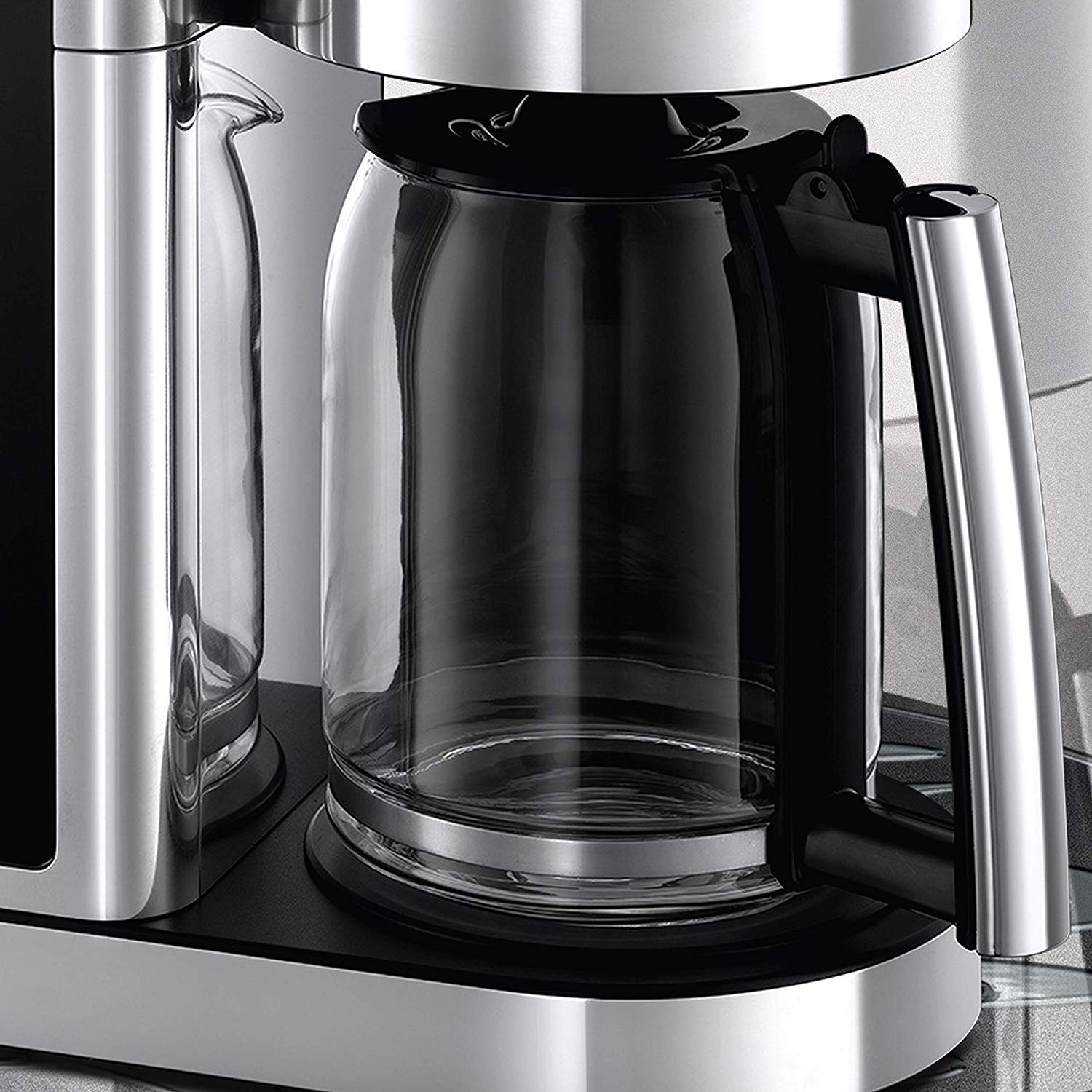 Nahaufnahme einer Kaffeemaschine. Eine klare Glaskaraffe und ein schwarzer Griff sind sichtbar.