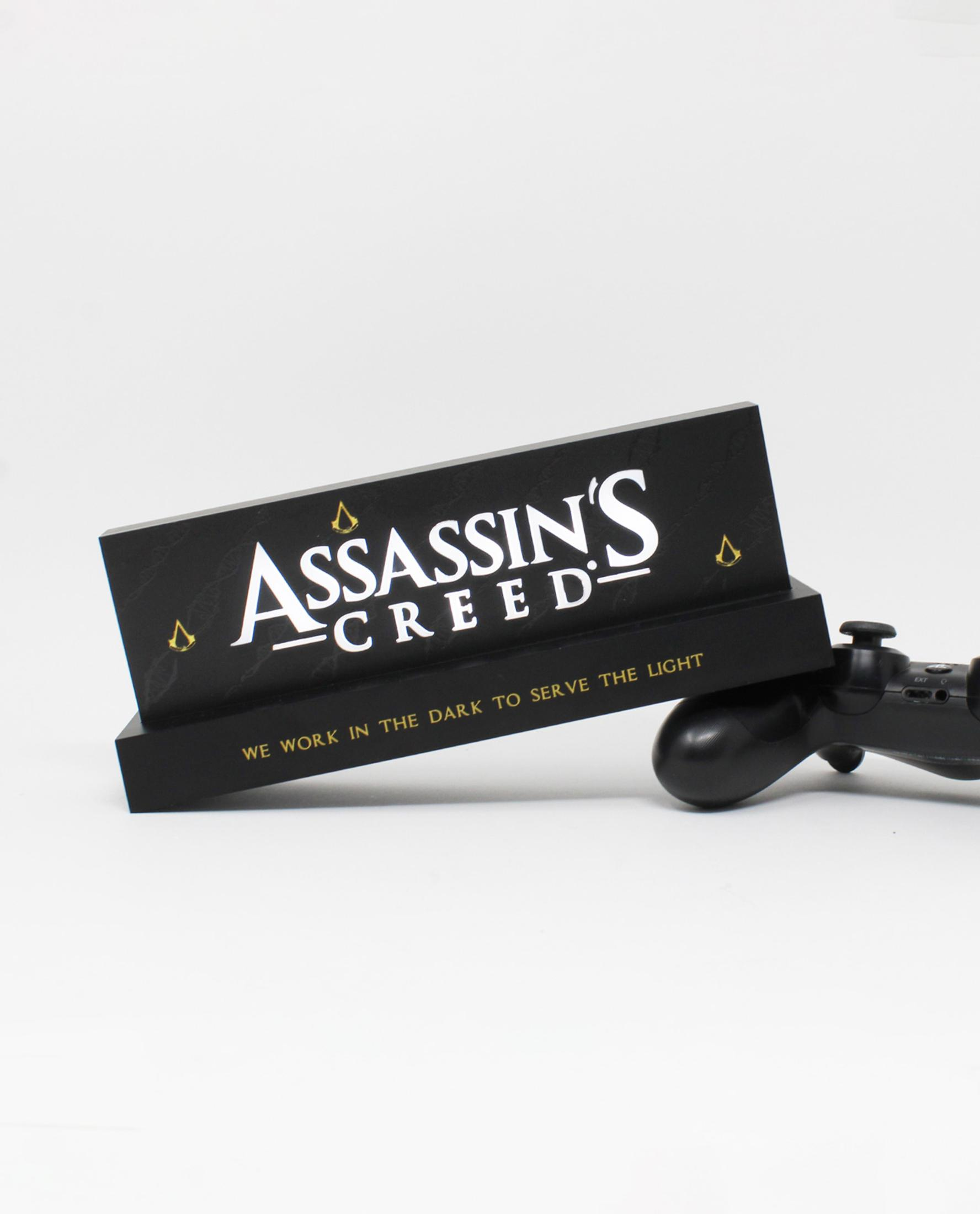 Ein Assassin's Creed-Schild mit einem Controller. Das Schild sagt 'Assassin's Creed' in Weiß.