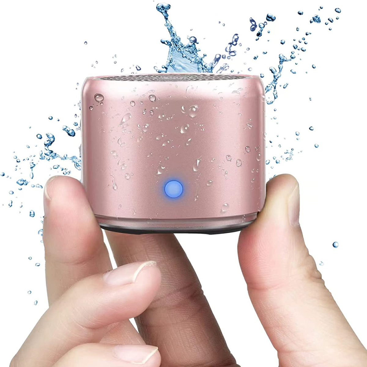 Rosa, wasserspritzender Mini-Lautsprecher in Händen, mit blauer Betriebsanzeige.