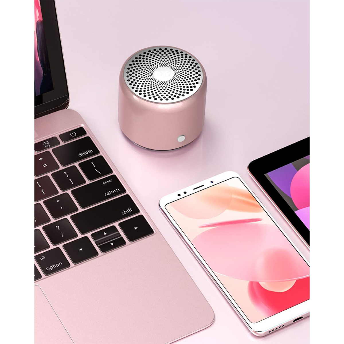 Rosa Lautsprecher, Laptop, Smartphone und Tablet auf rosa Oberfläche. Nahaufnahme.