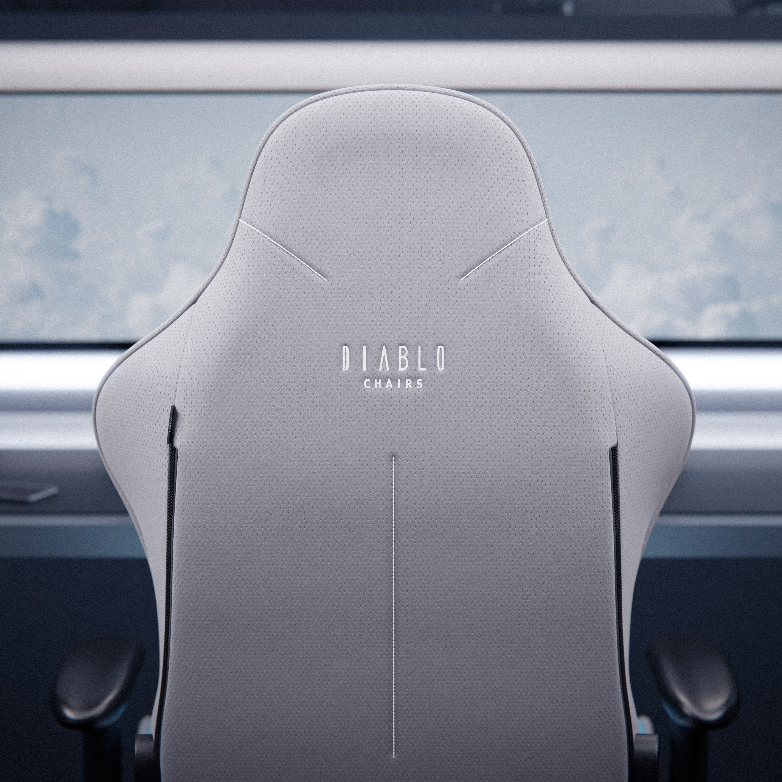 Oparcie fotela gamingowego, szare i białe z logo Diablo Chairs. Tło jest rozmyte.
