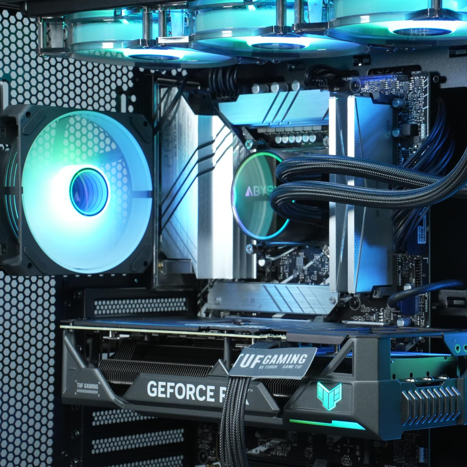 Interior de computadora con iluminación LED azul y verde azulado. Se ve la tarjeta gráfica y el sistema de enfriamiento de la CPU.