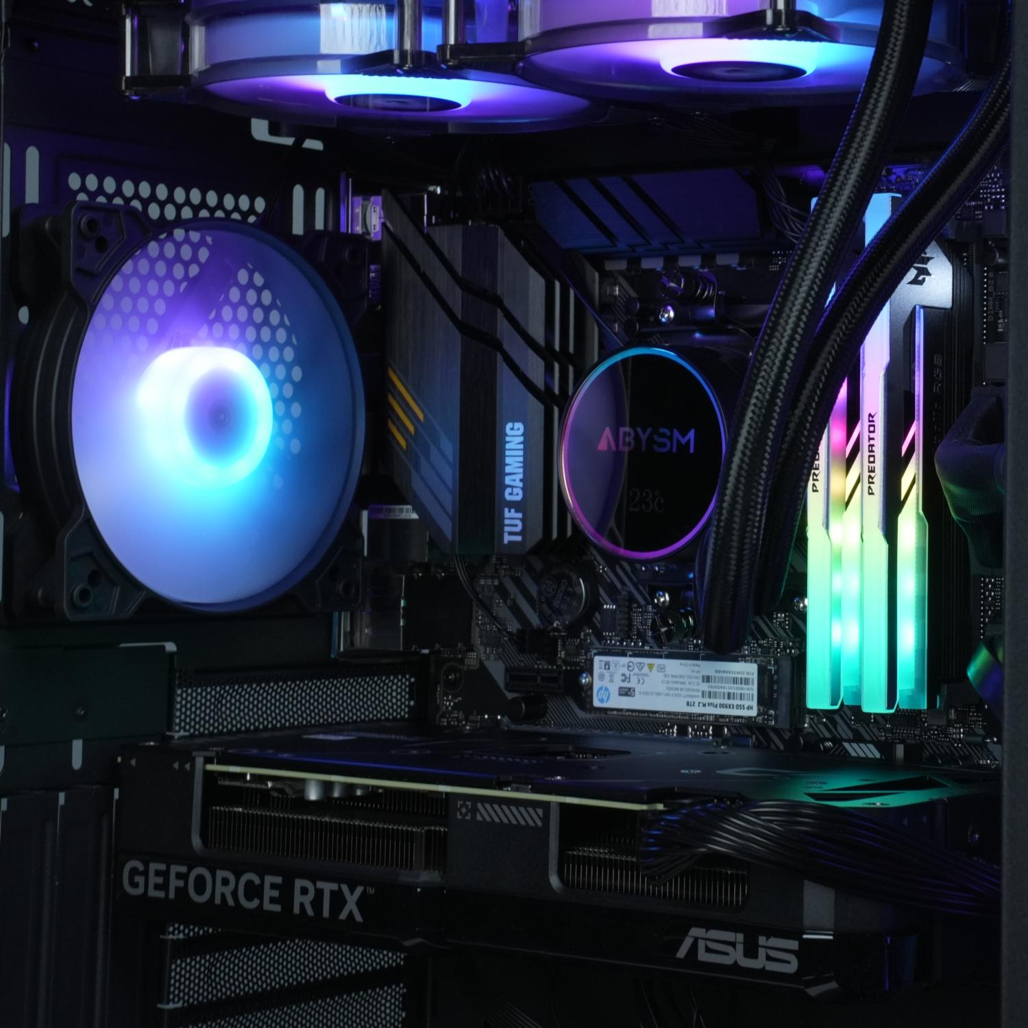 Vista interior de PC: GPU, enfriador de CPU con logo ABYSM, luces azules y verdes, RAM y placa base ASUS.