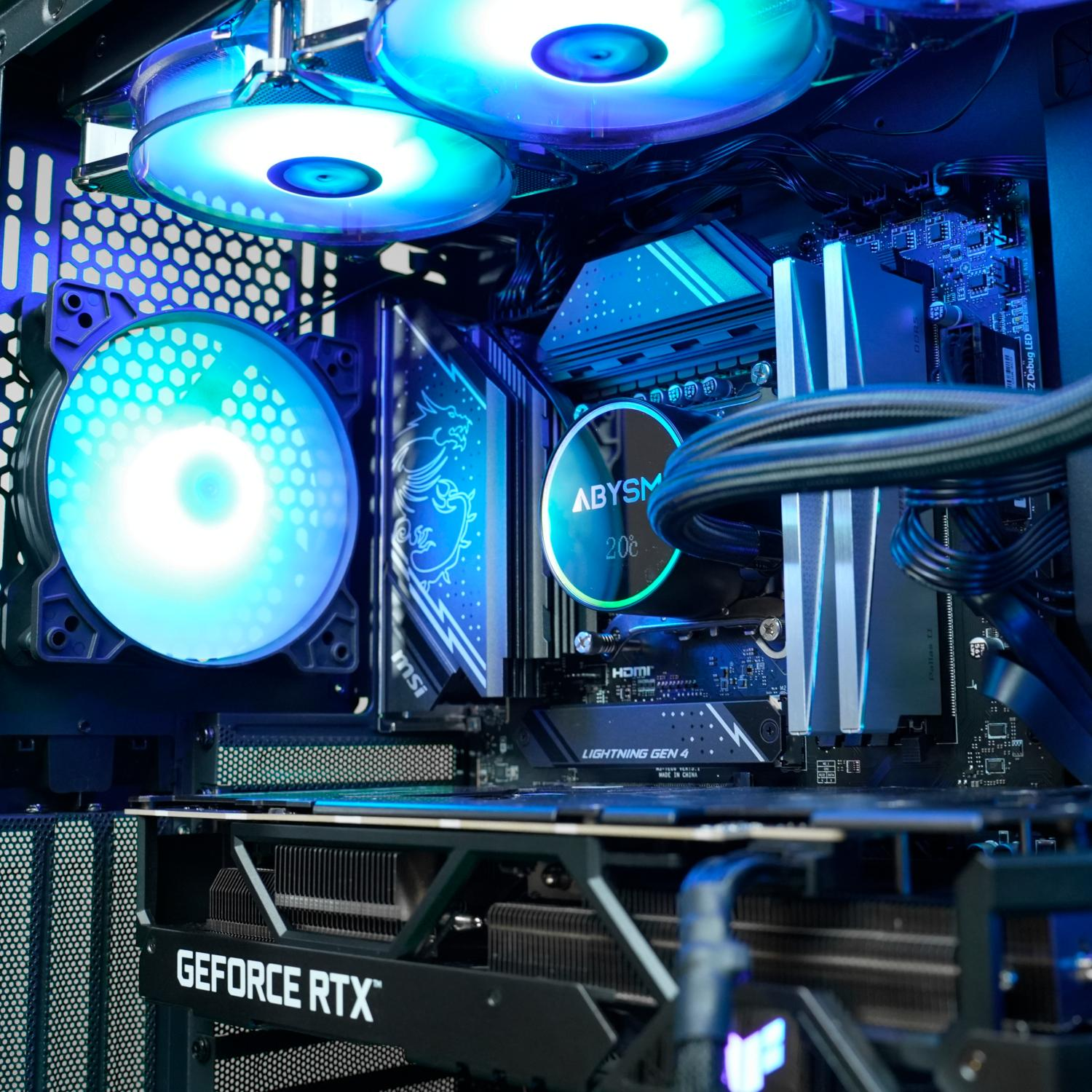 Dentro de una computadora, con ventiladores iluminados, una placa base y una tarjeta gráfica con luces azules.