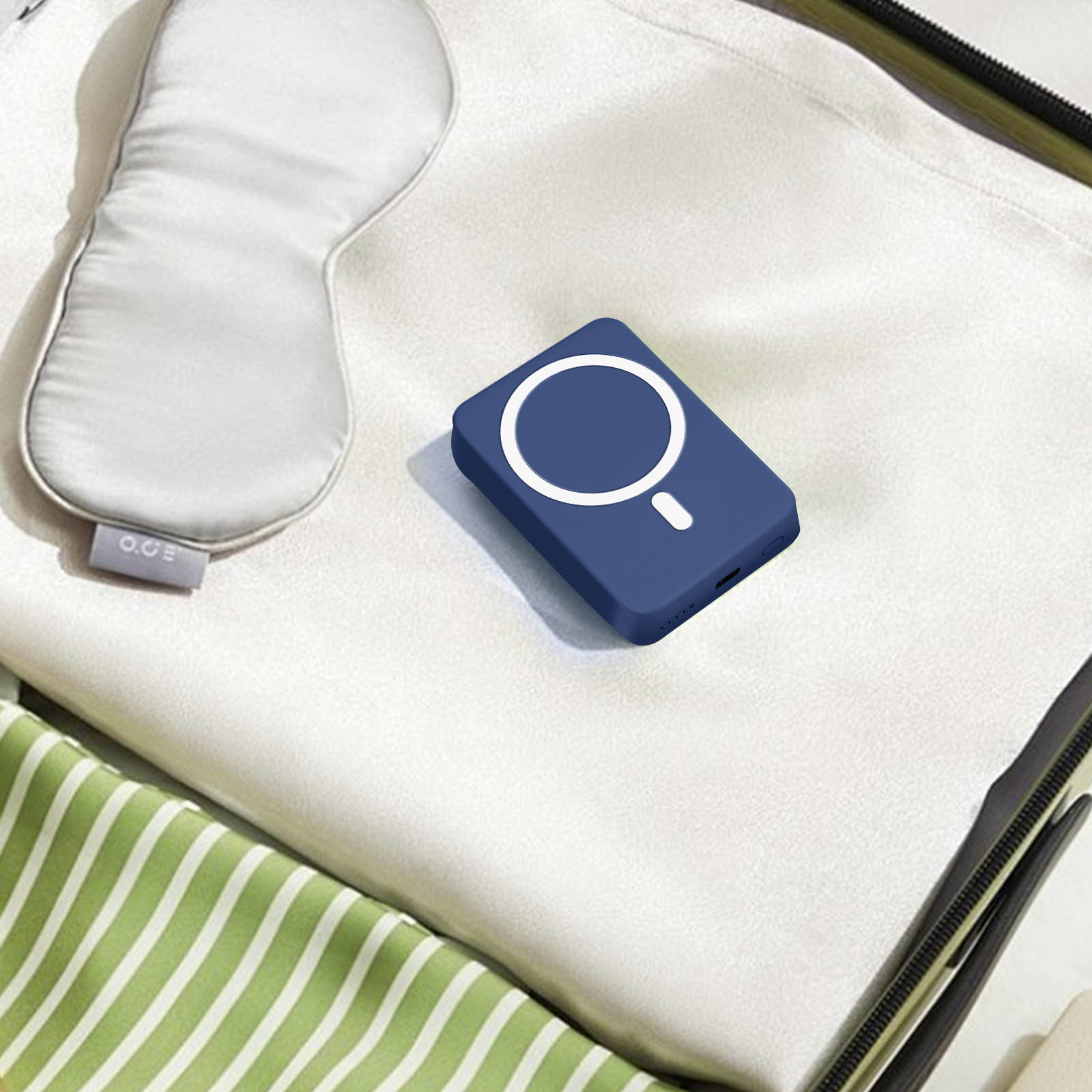 Dispositivo de carga azul con círculo blanco, colocado sobre tela blanca, con antifaz.