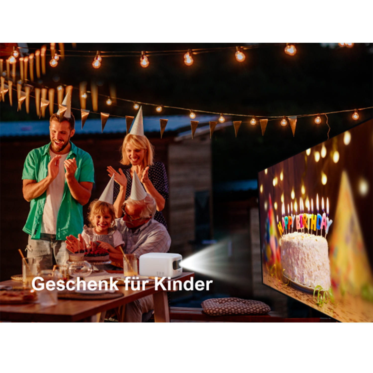 Eine Familie feiert Geburtstag mit einem Projektor, der eine Torte mit Kerzen zeigt.