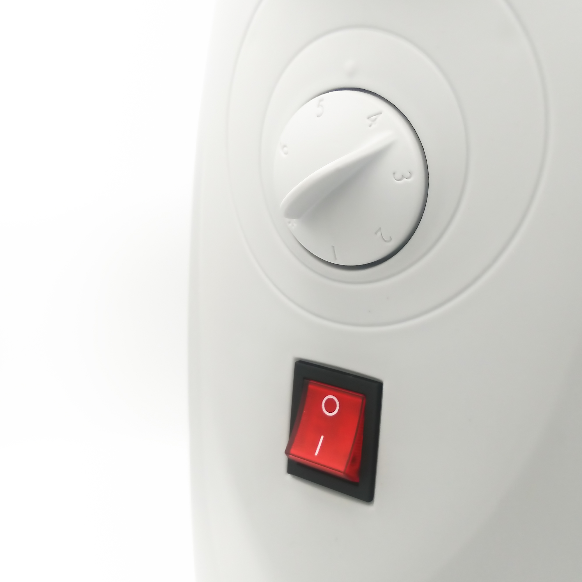 Primer plano de un panel de control de electrodomésticos blanco con un dial y un interruptor de encendido rojo.